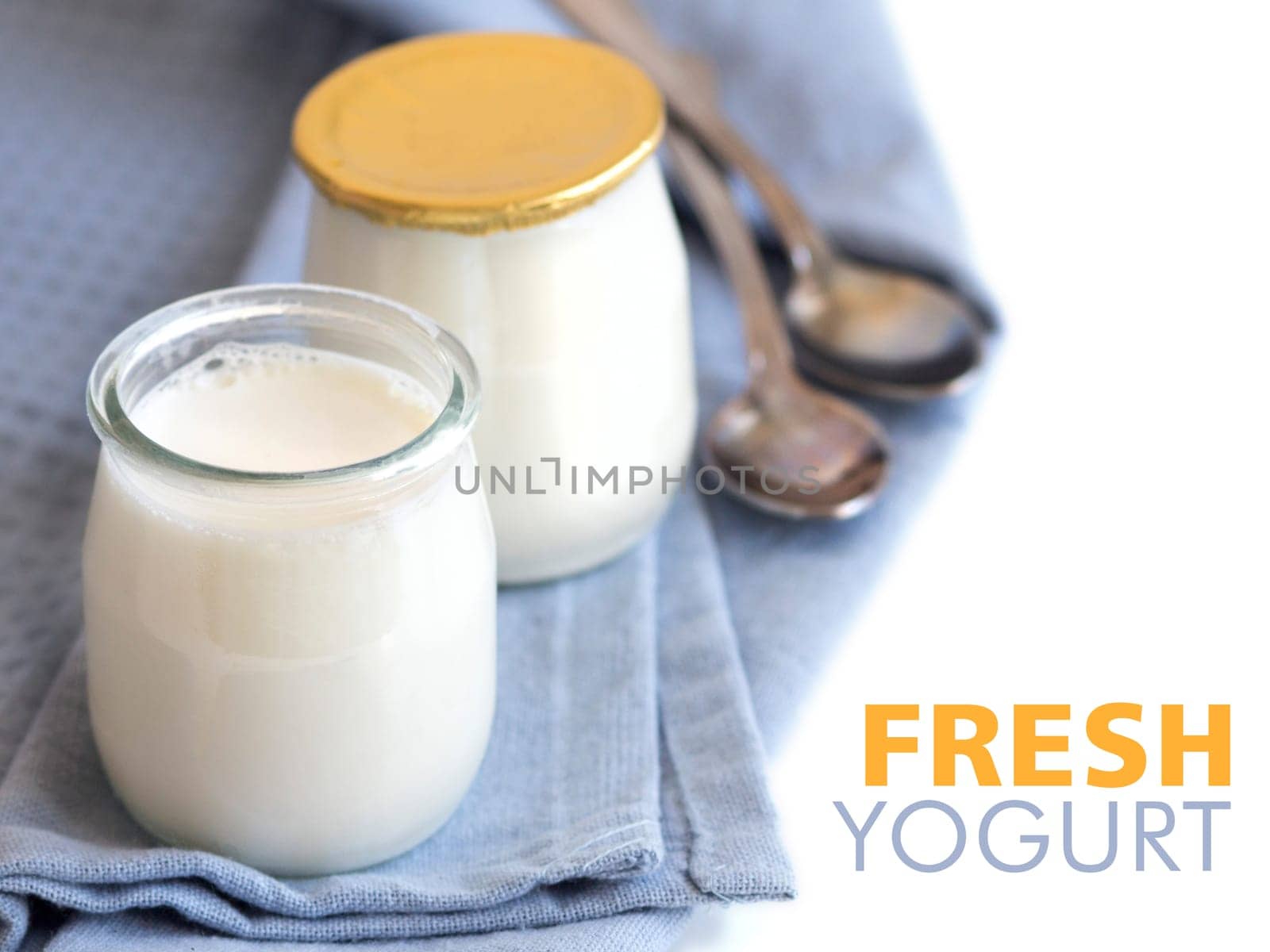 Jars of fresh natural yogurt on the light blue napkin