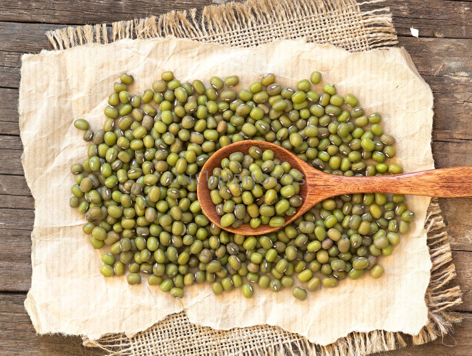 Mung beans and spoon on a wooden table