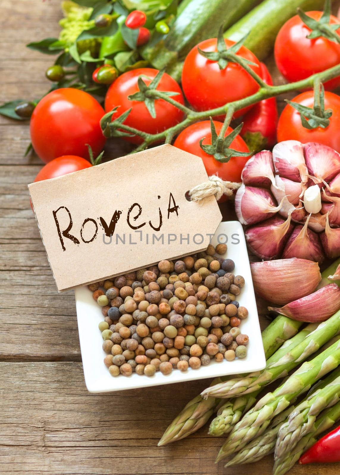 Raw organic roveja beans and vegetables on wooden table