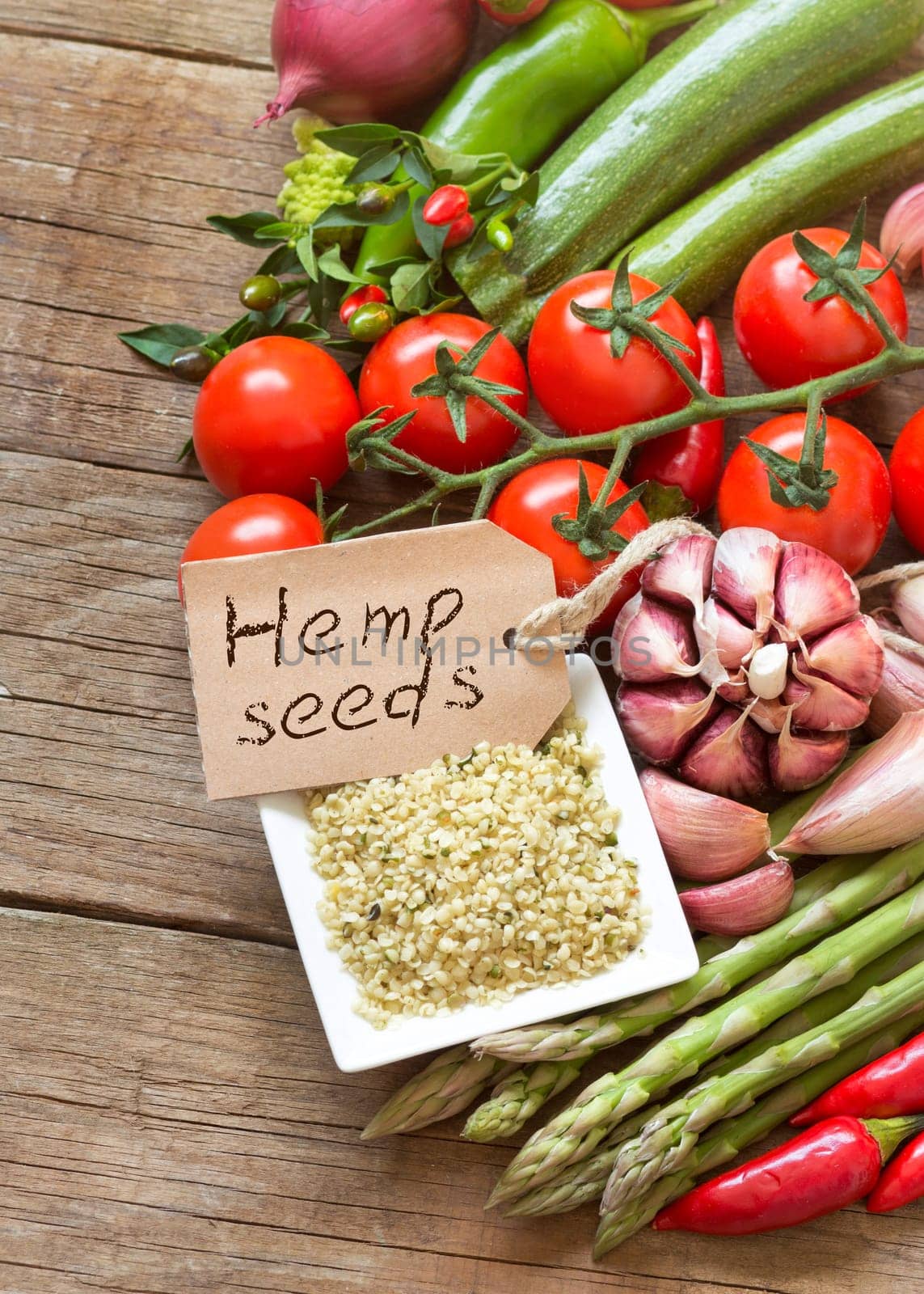 Raw organic hemp seeds and vegetables on a wooden table