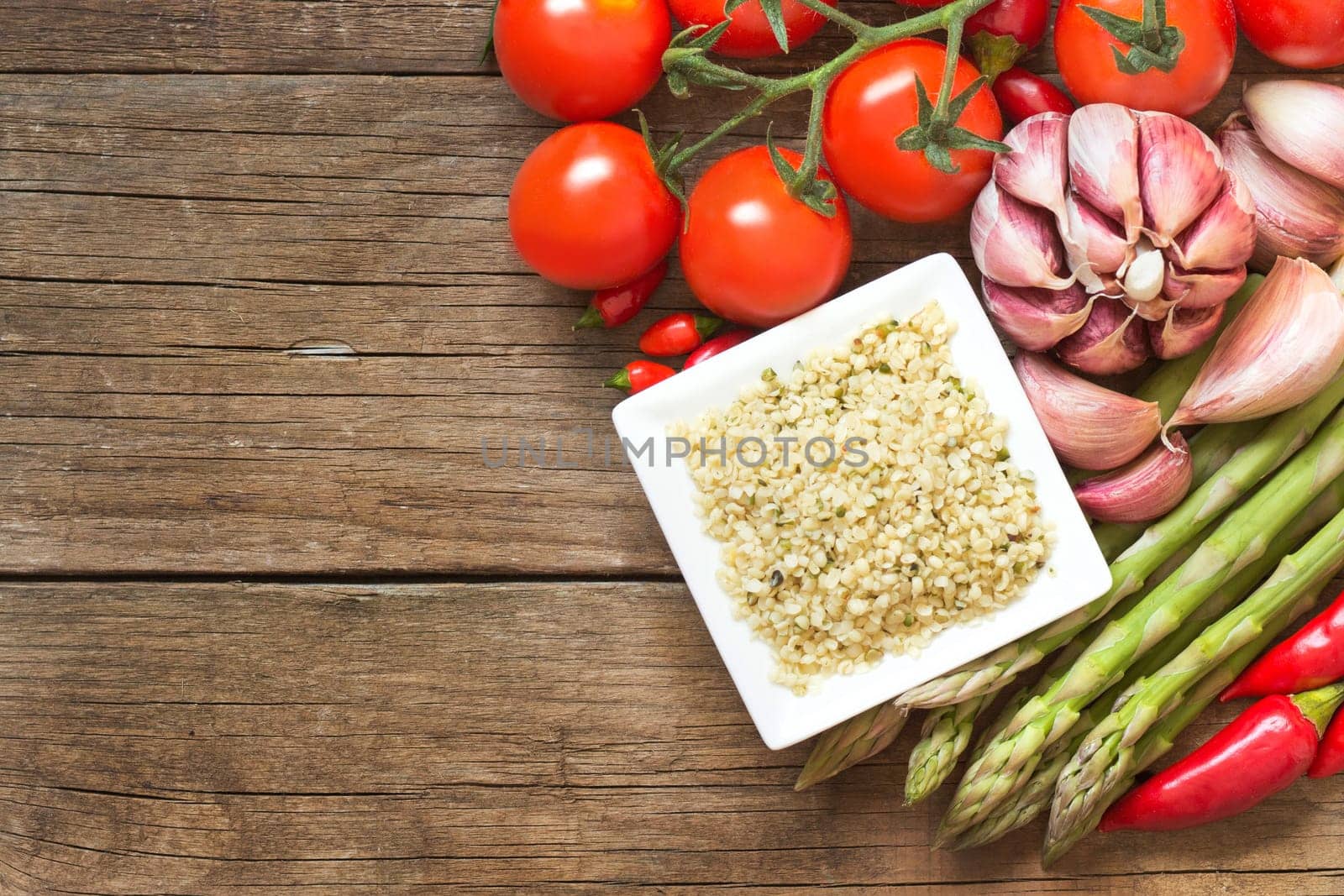 Raw organic hemp seeds and vegetables on a wooden table