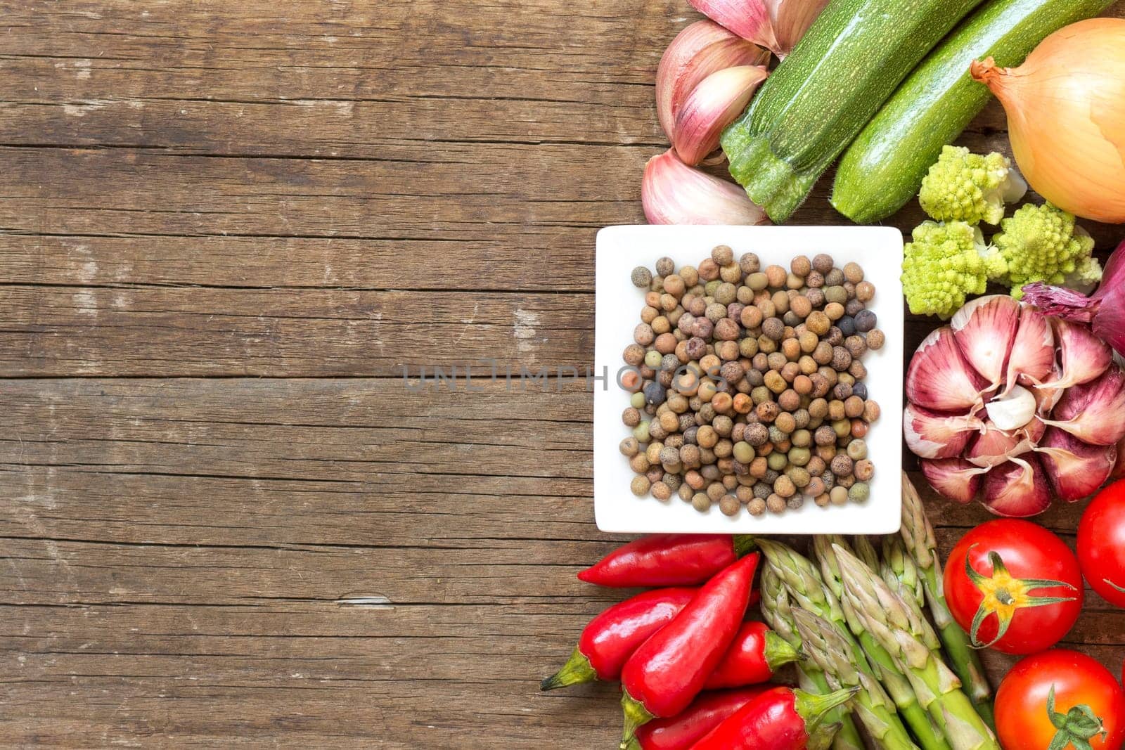 Raw organic roveja beans and vegetables on wooden table
