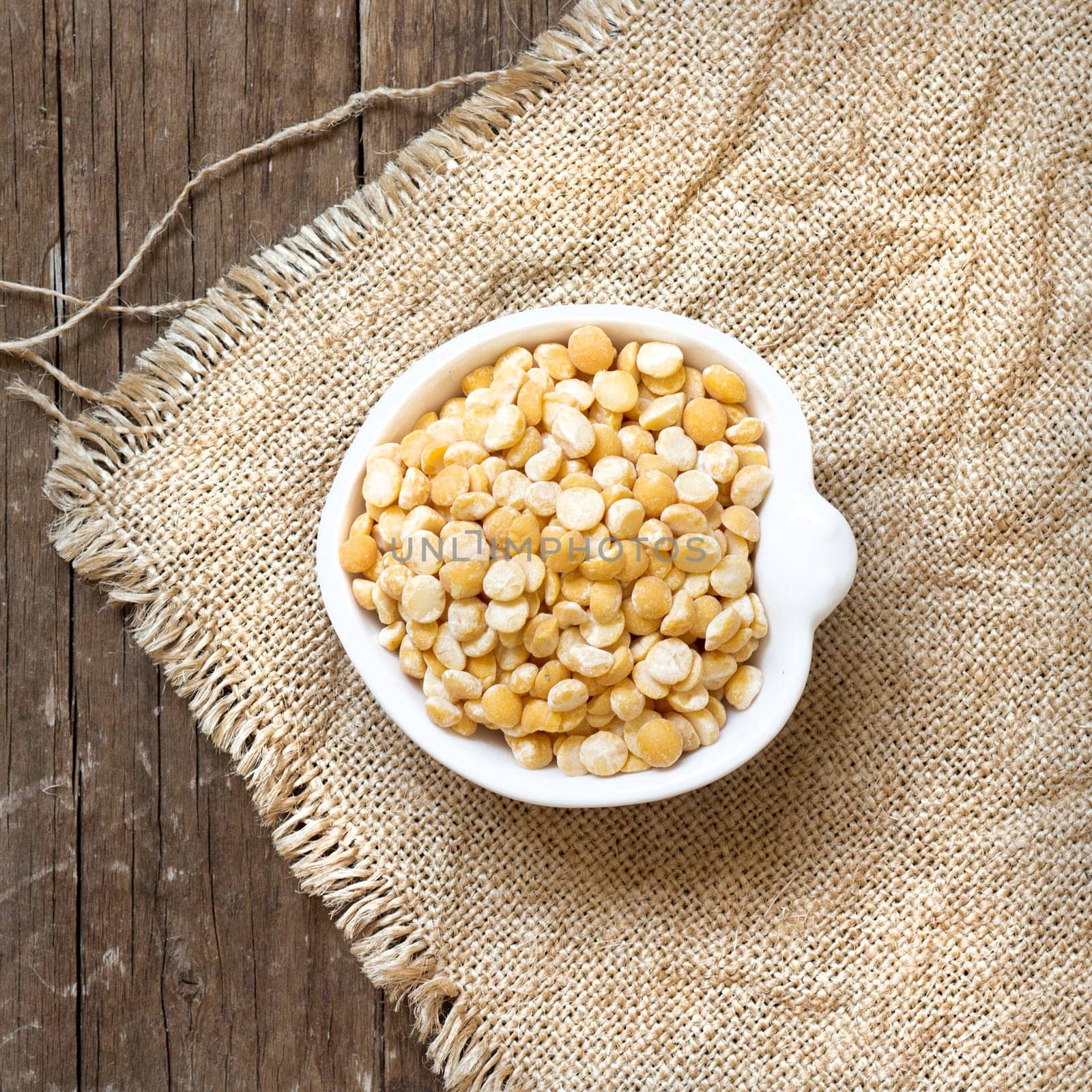Yellow peas in a bowl on burlap
