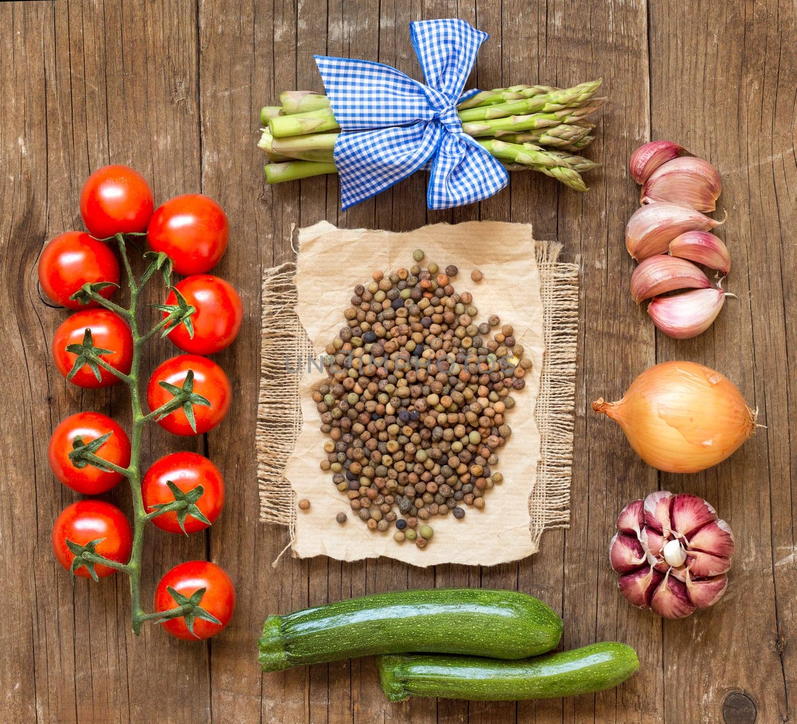 Raw organic roveja beans and vegetables on wooden table
