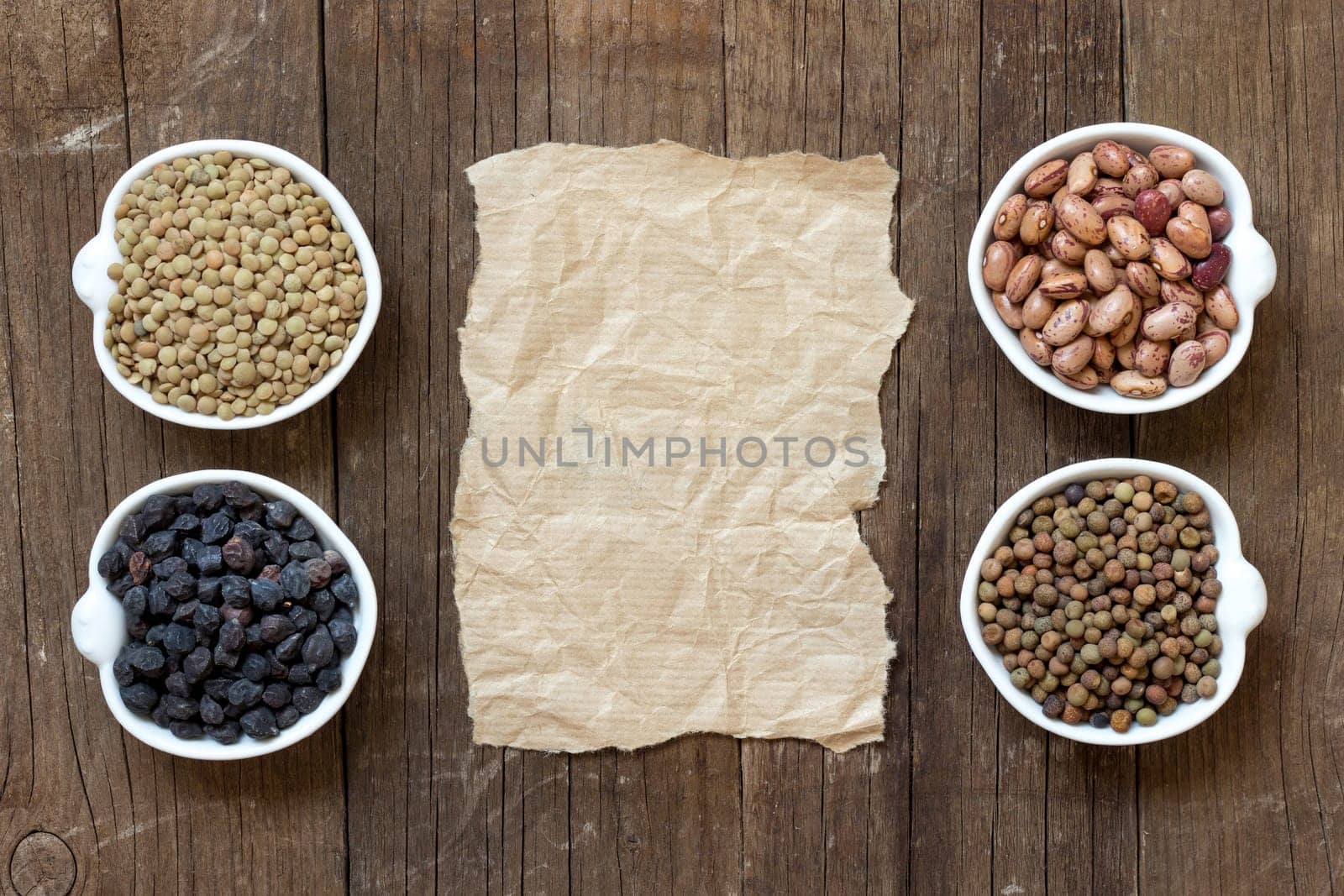 Variety or legumes and paper on a wooden table