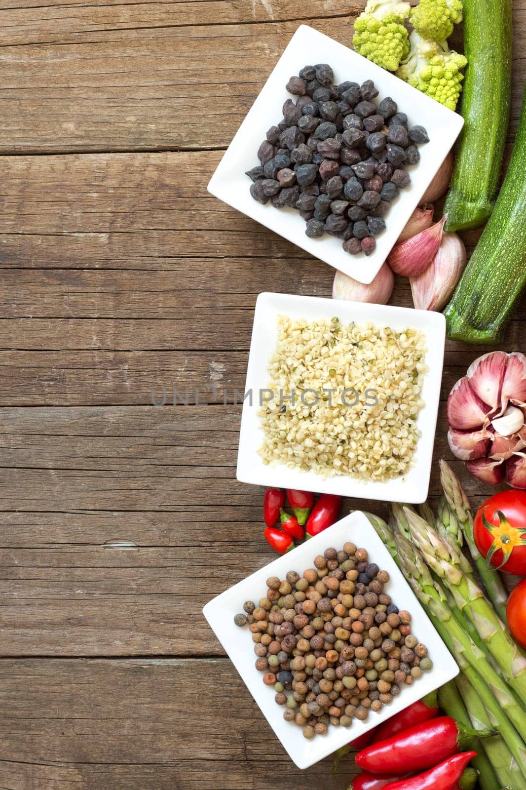 Roveja, hemp seeds, black chickpea and vegetables on a wooden table