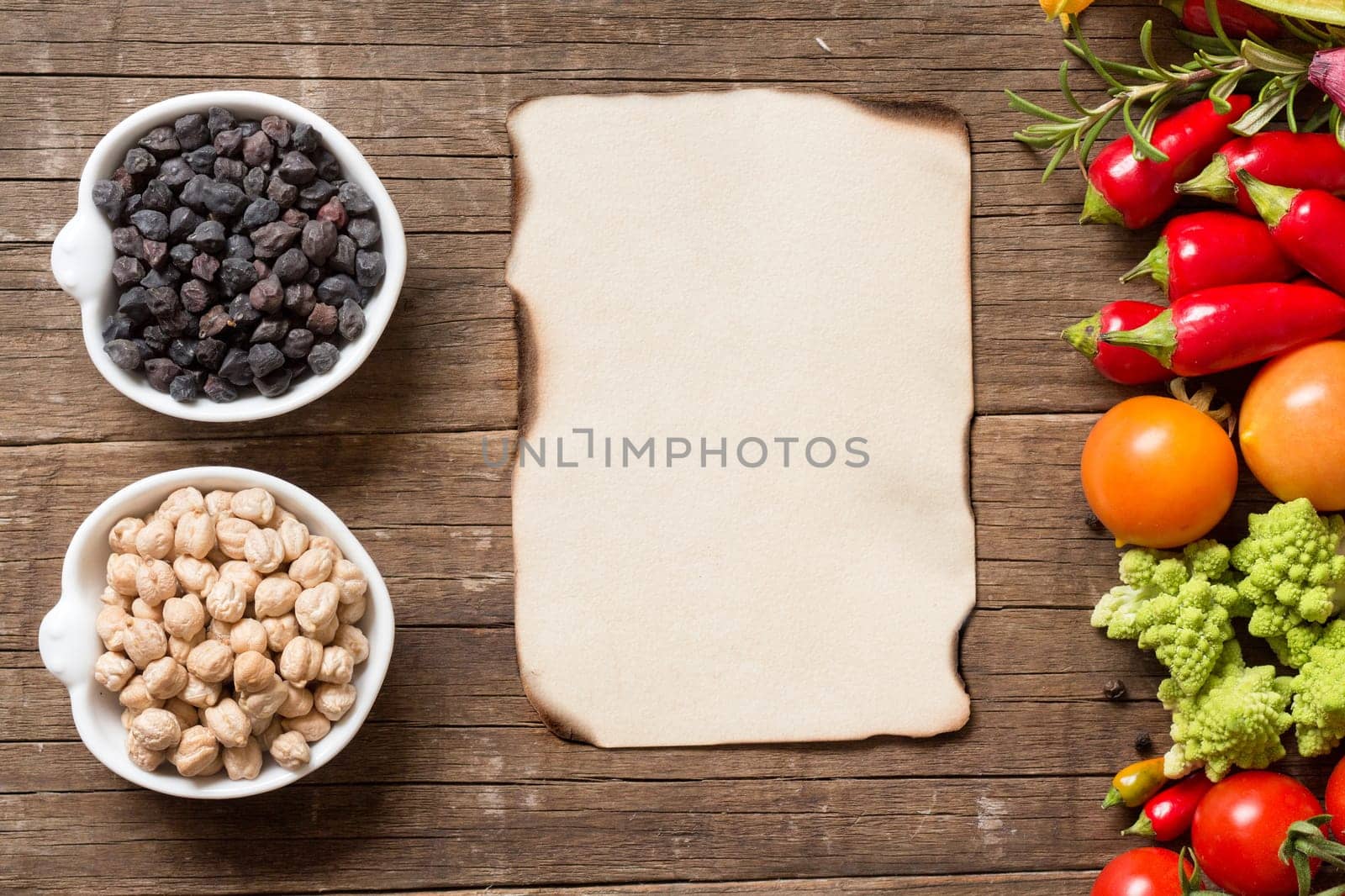 Vegetables, paper and chickpea on a wooden table background