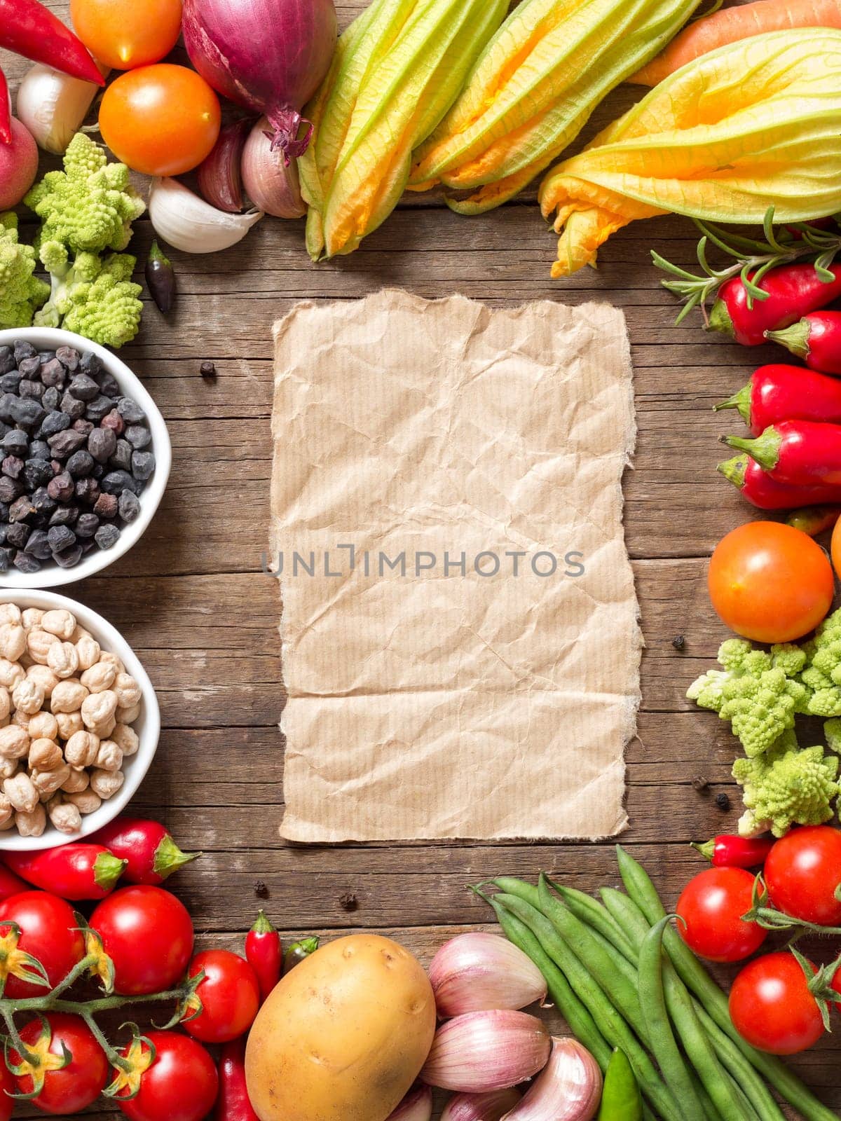 Vegetables, paper and chickpea on a wooden table background