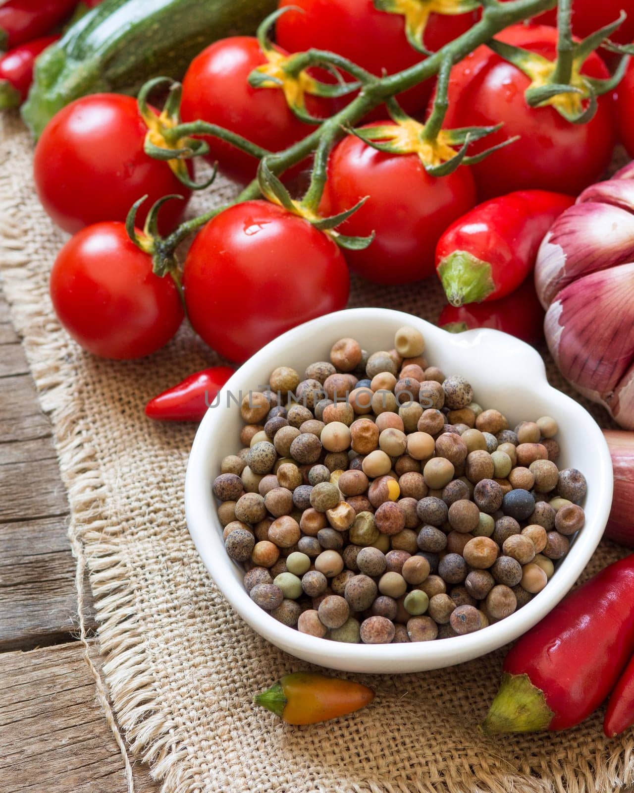 Raw organic roveja beans and vegetables on wooden table