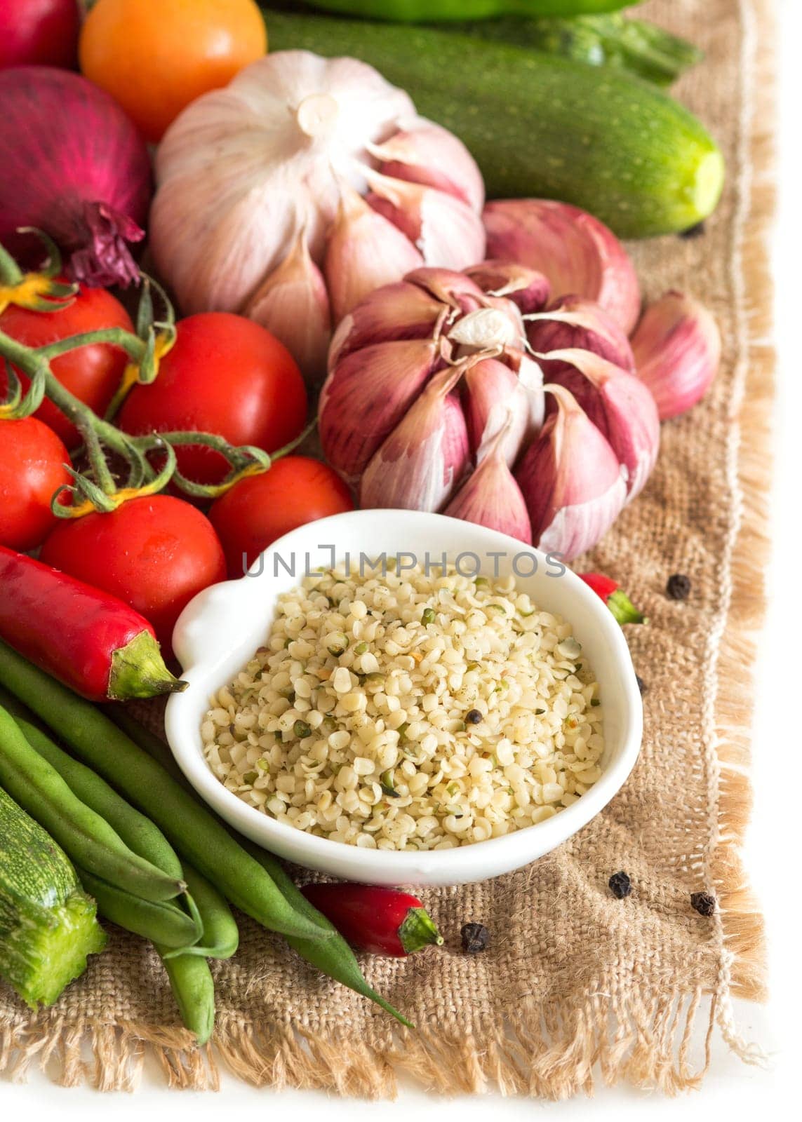 Raw organic hemp seeds in a bowl and vegetables