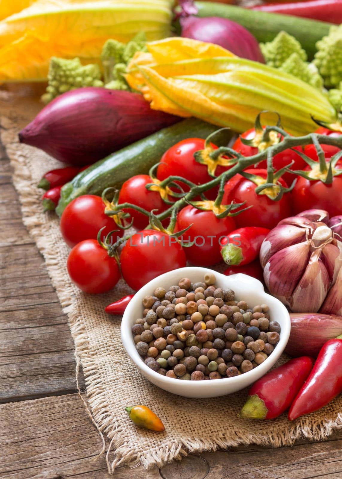 Raw organic roveja beans and vegetables on wooden table
