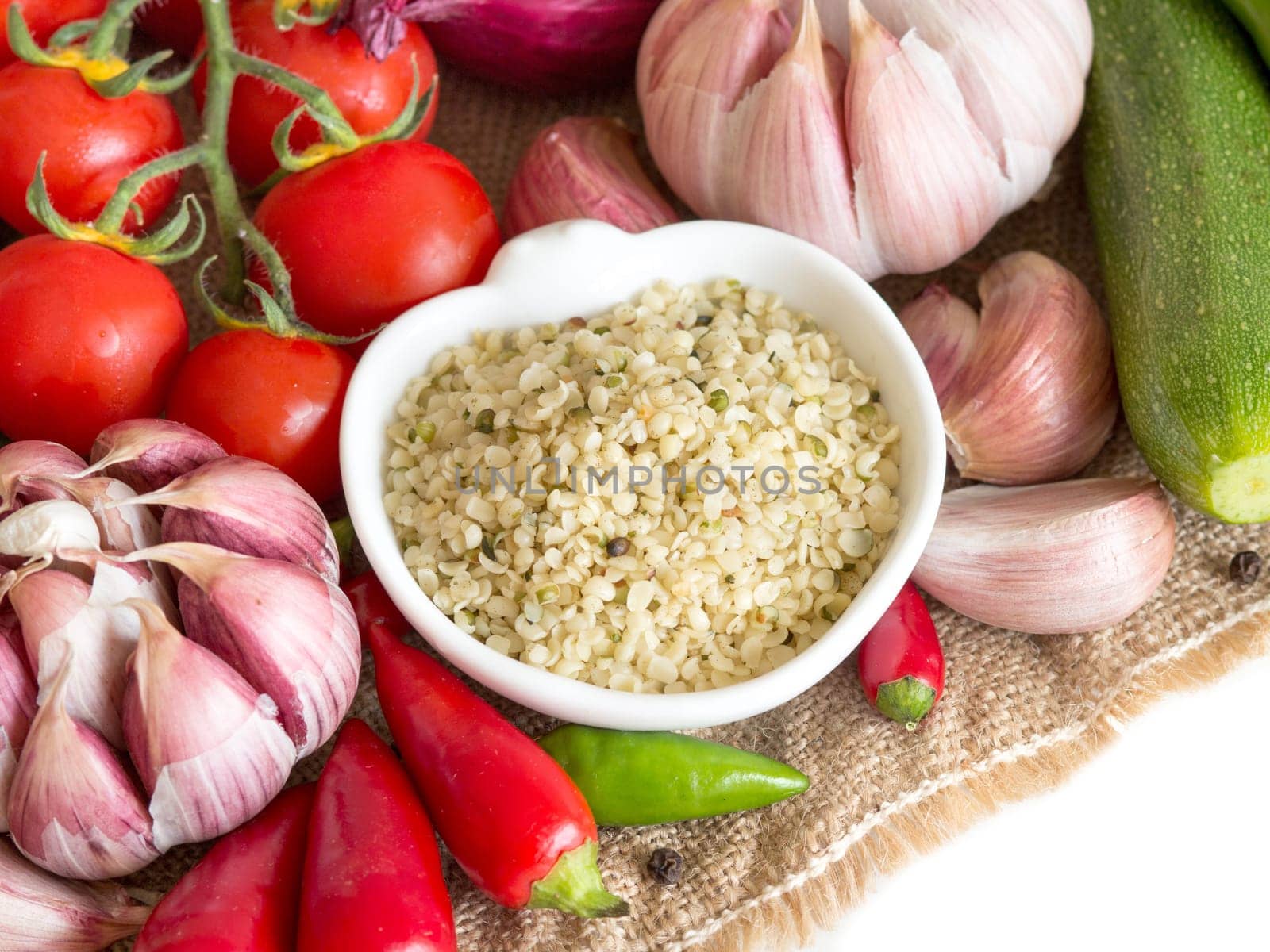 Raw organic hemp seeds in a bowl and vegetables