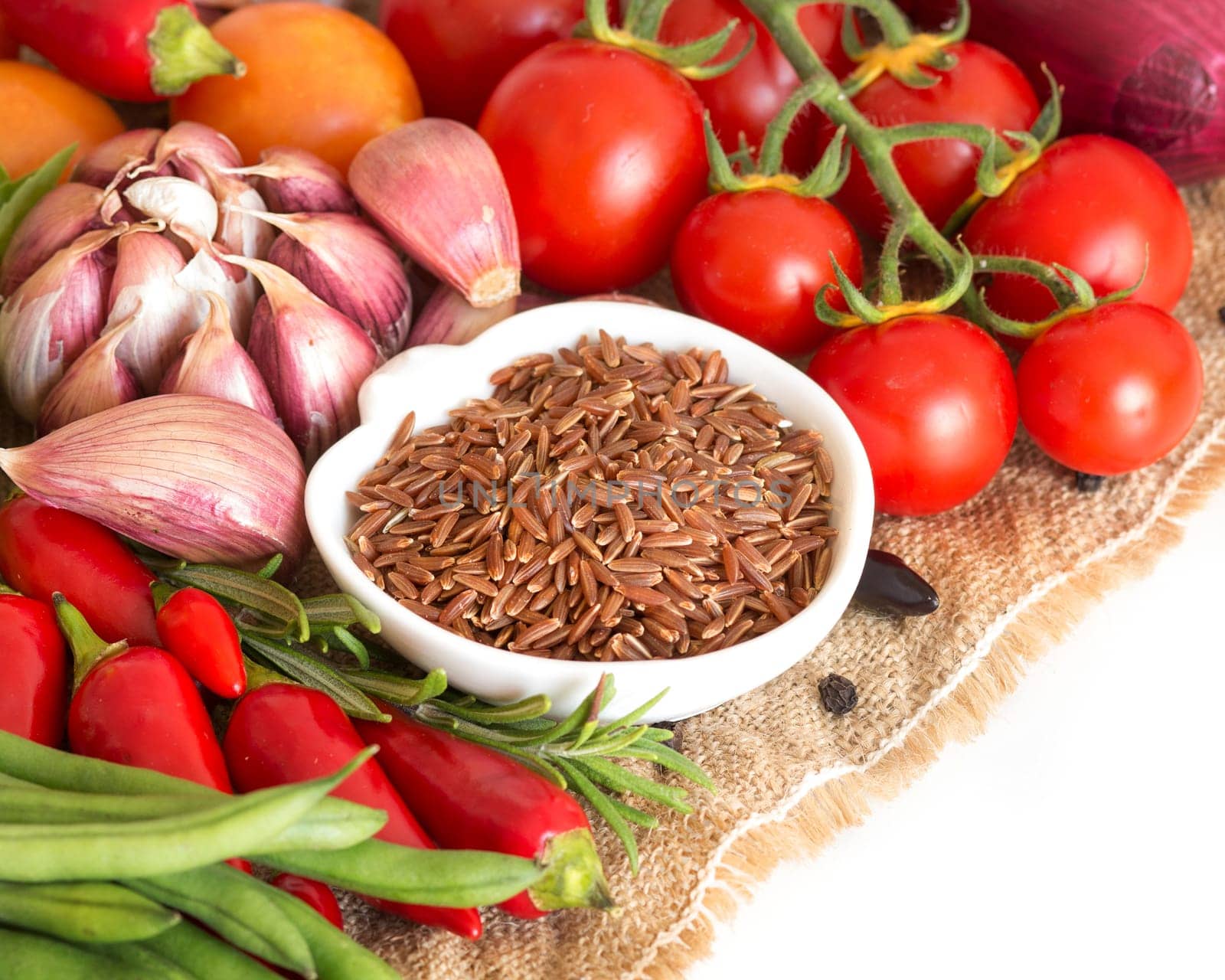 Red organic rice in bowl and vegetables
