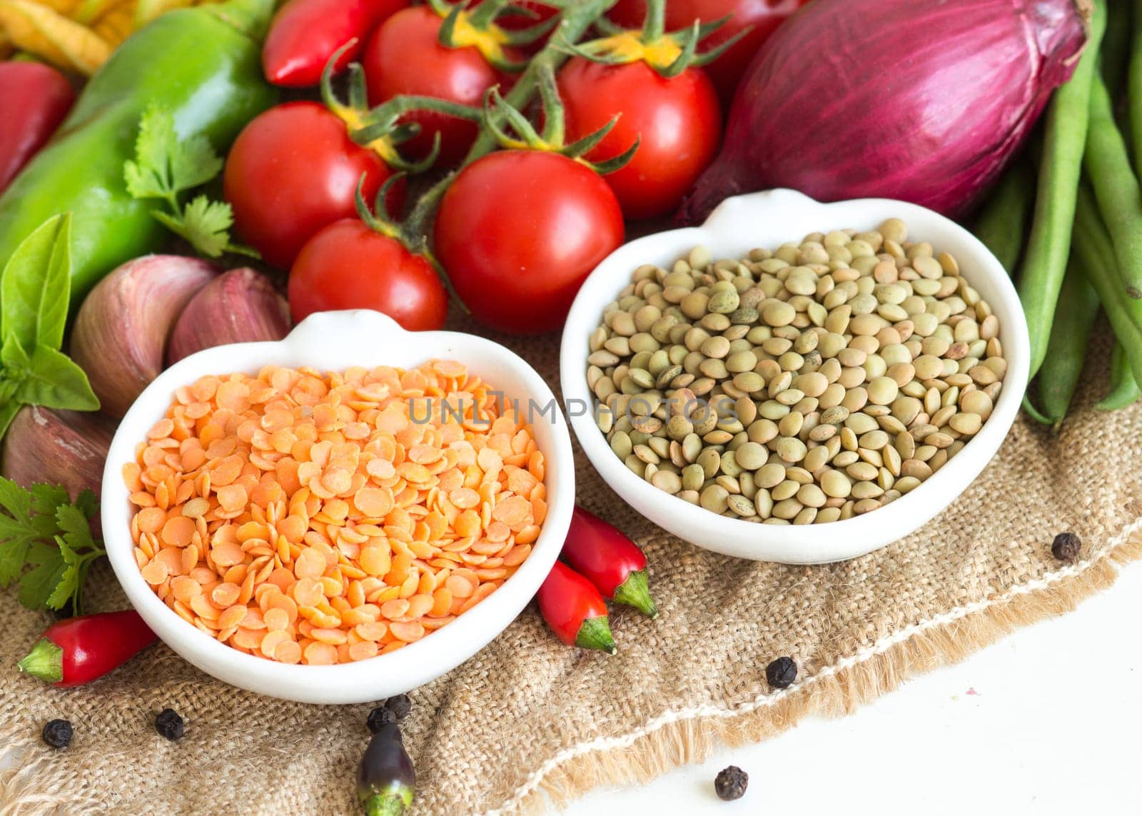 Red and green lentils and vegetables isolated on white