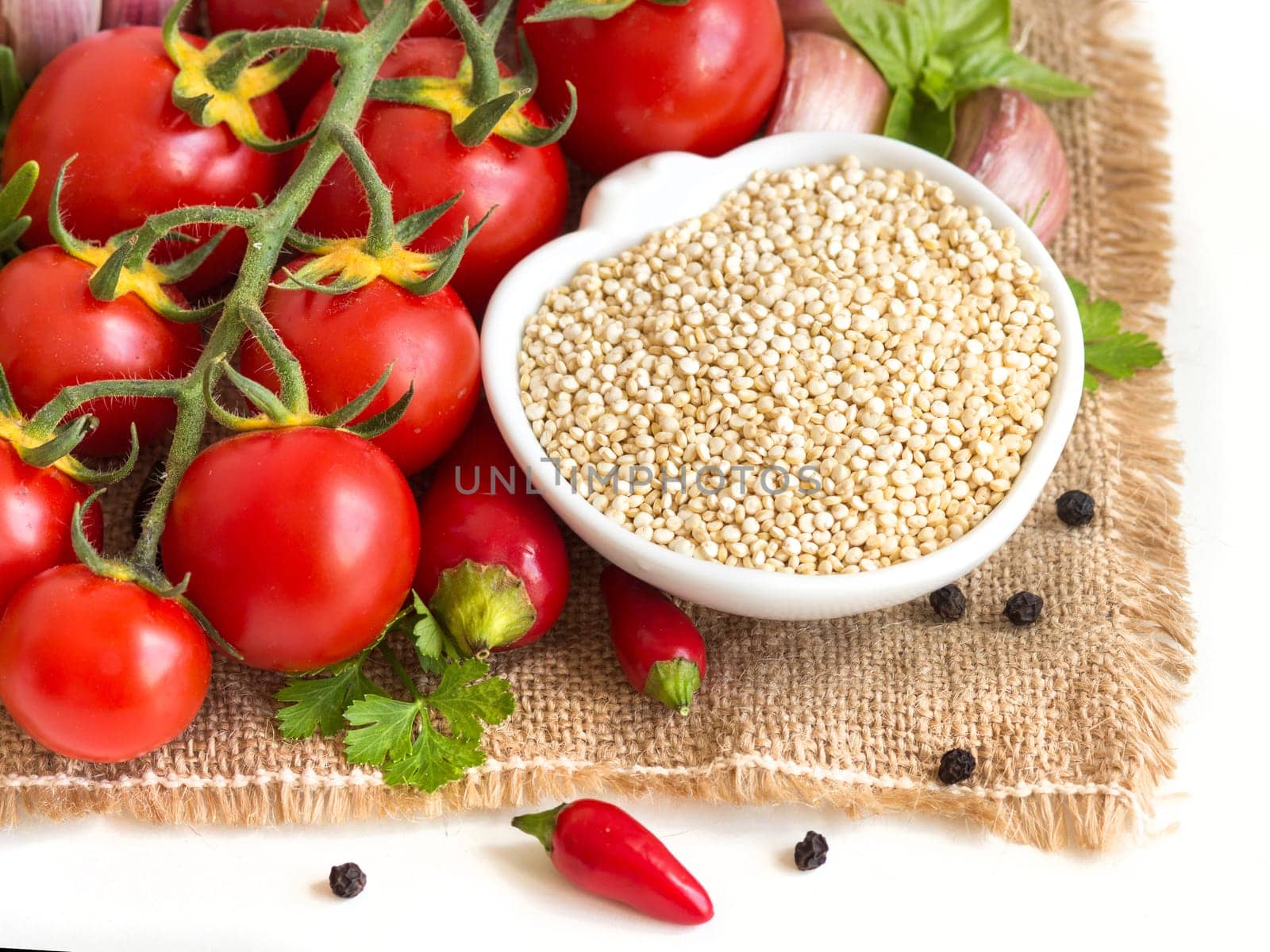 Raw organic quinoa in a bowl and vegetables