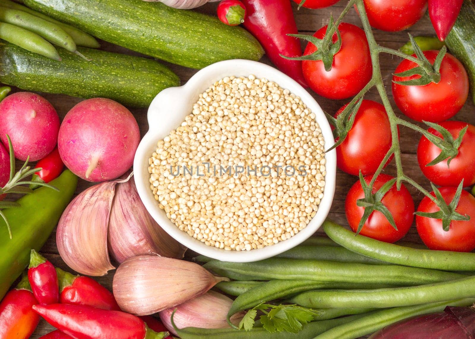 Raw organic quinoa in a bowl and vegetables