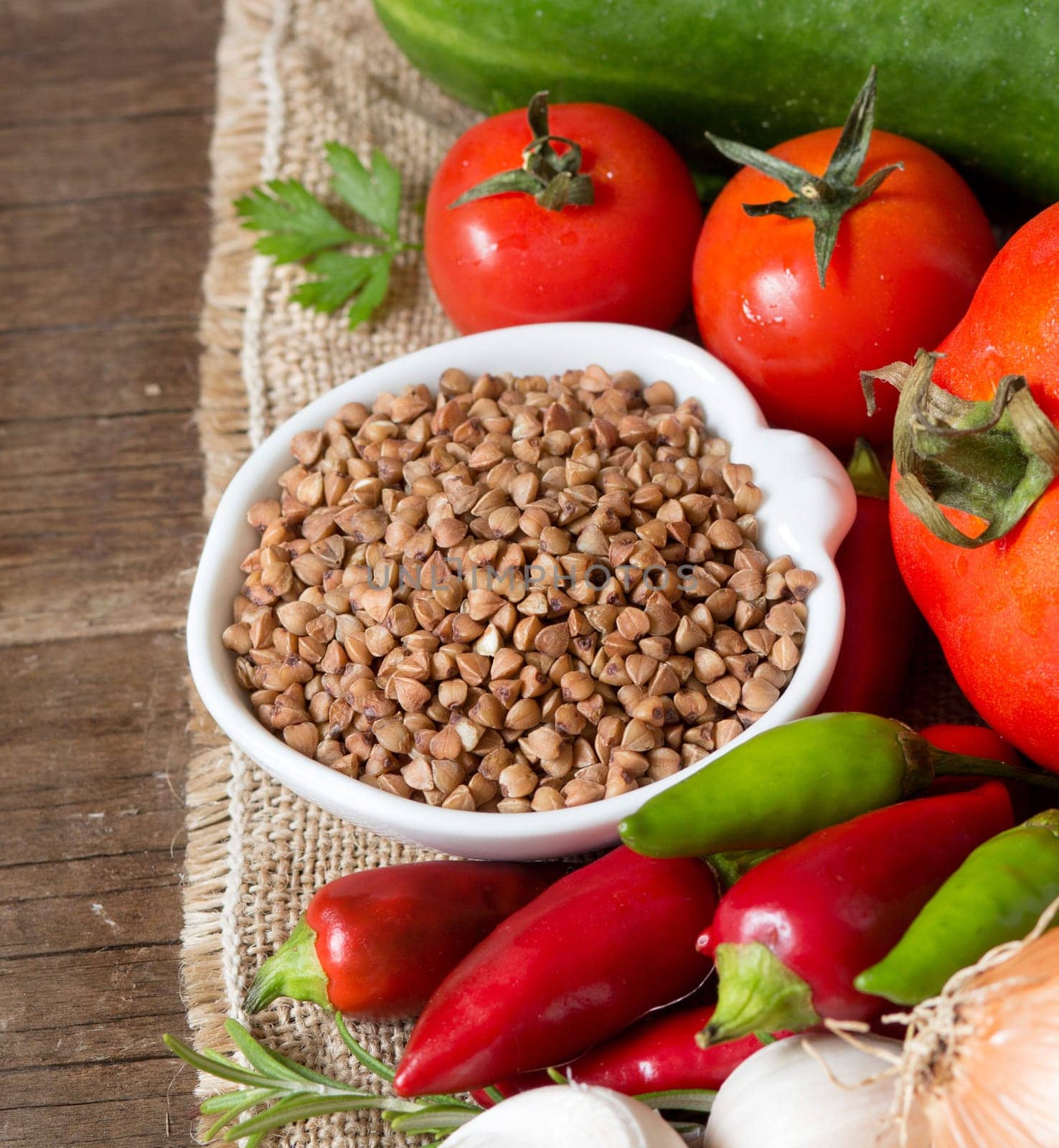 Raw Organic buckwheat and vegetables on wooden table