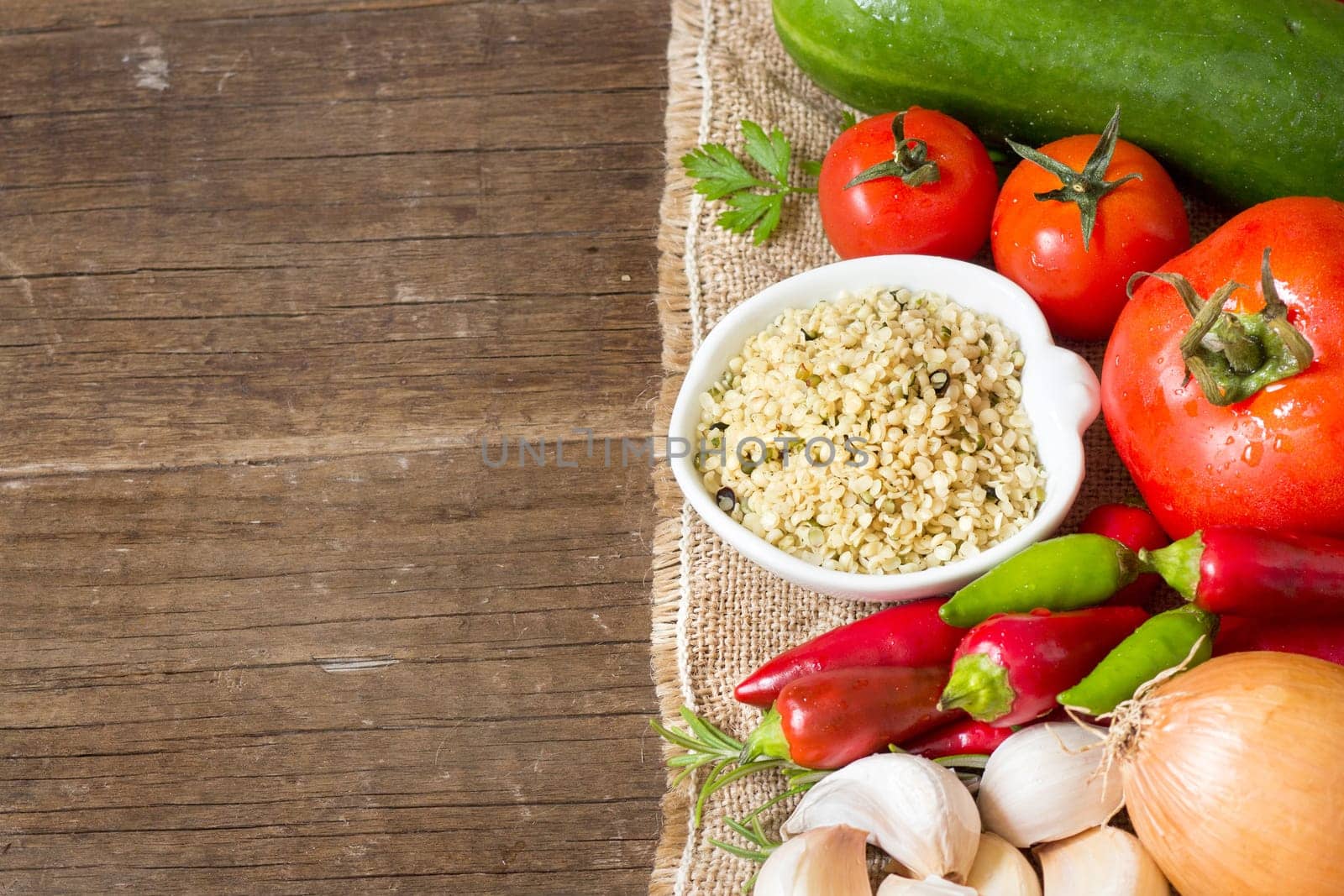Raw Organic hemp seeds and vegetables on wooden table