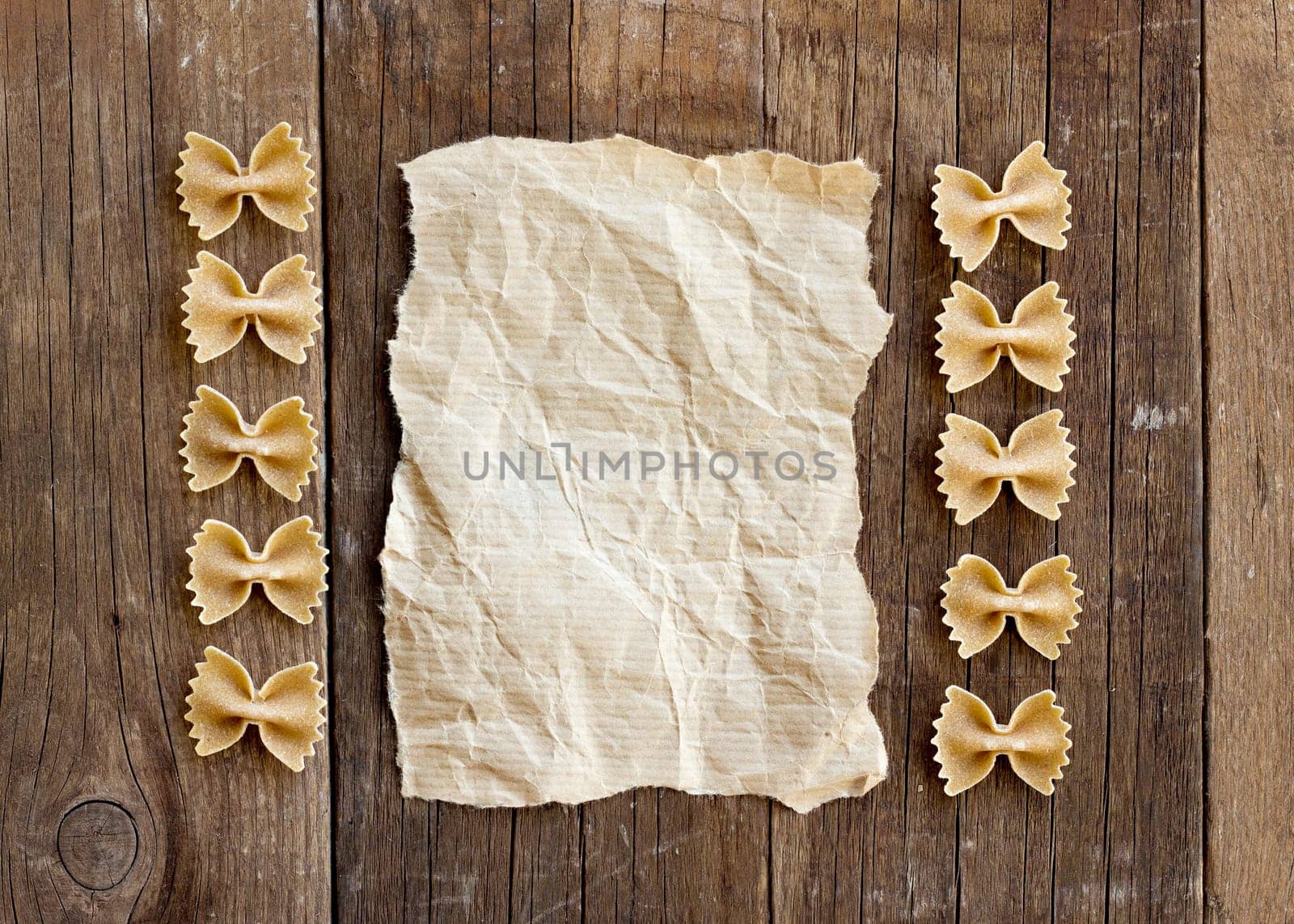 Pasta and paper on old wooden table