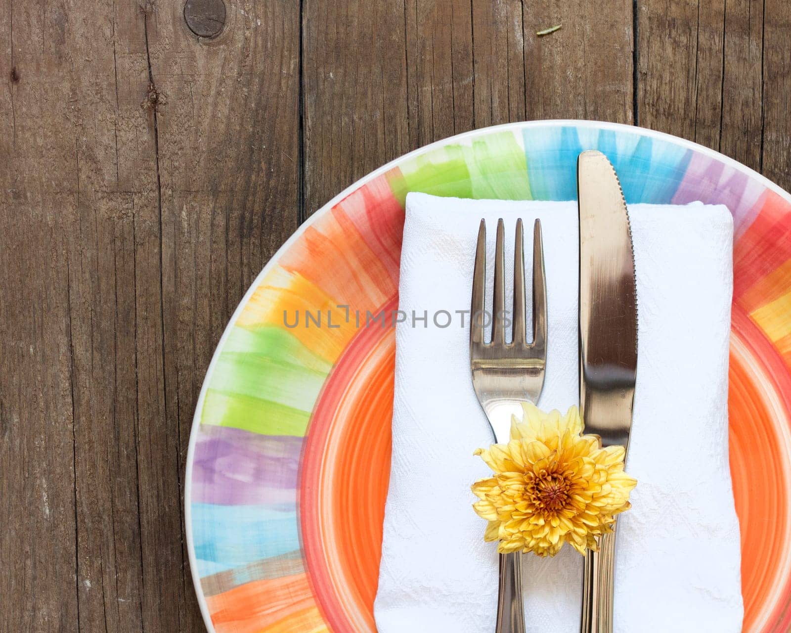 Colorful Table setting with yellow flower on old wooden table