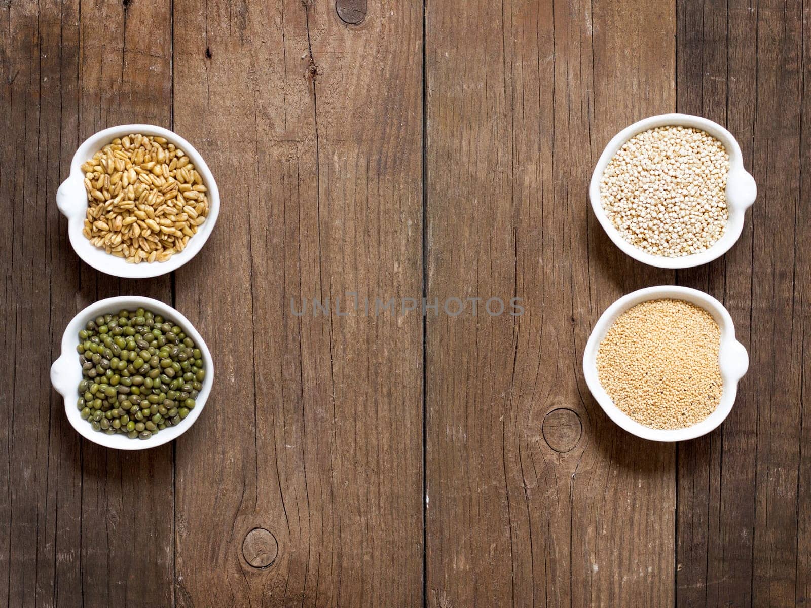 Raw Organic Amaranth and quinoa grains, wheat and mung beans in small bowls