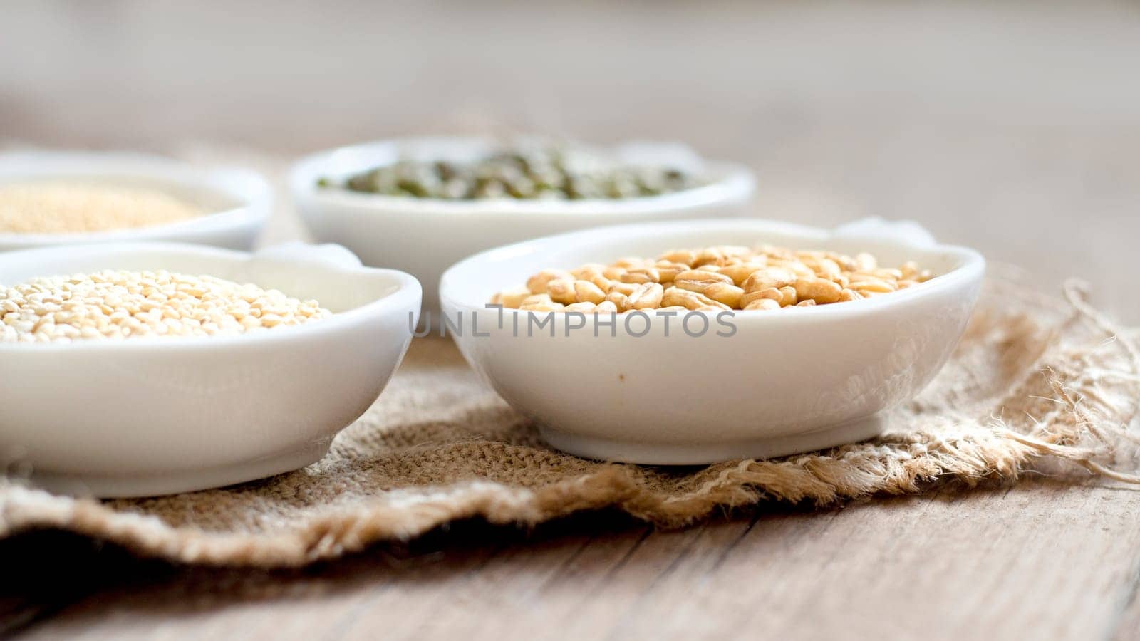 Raw Organic Amaranth and quinoa grains, wheat and mung beans in small bowls