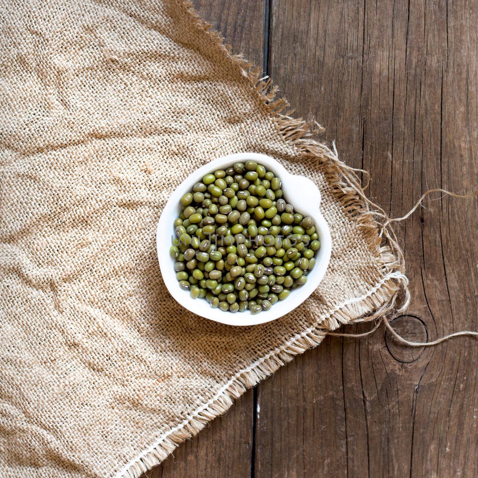 Raw Organic mung beans in a bowl on wooden table