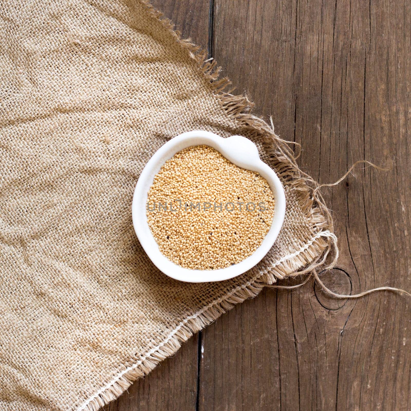 Raw Organic Amaranth grain in a bowl on wooden table