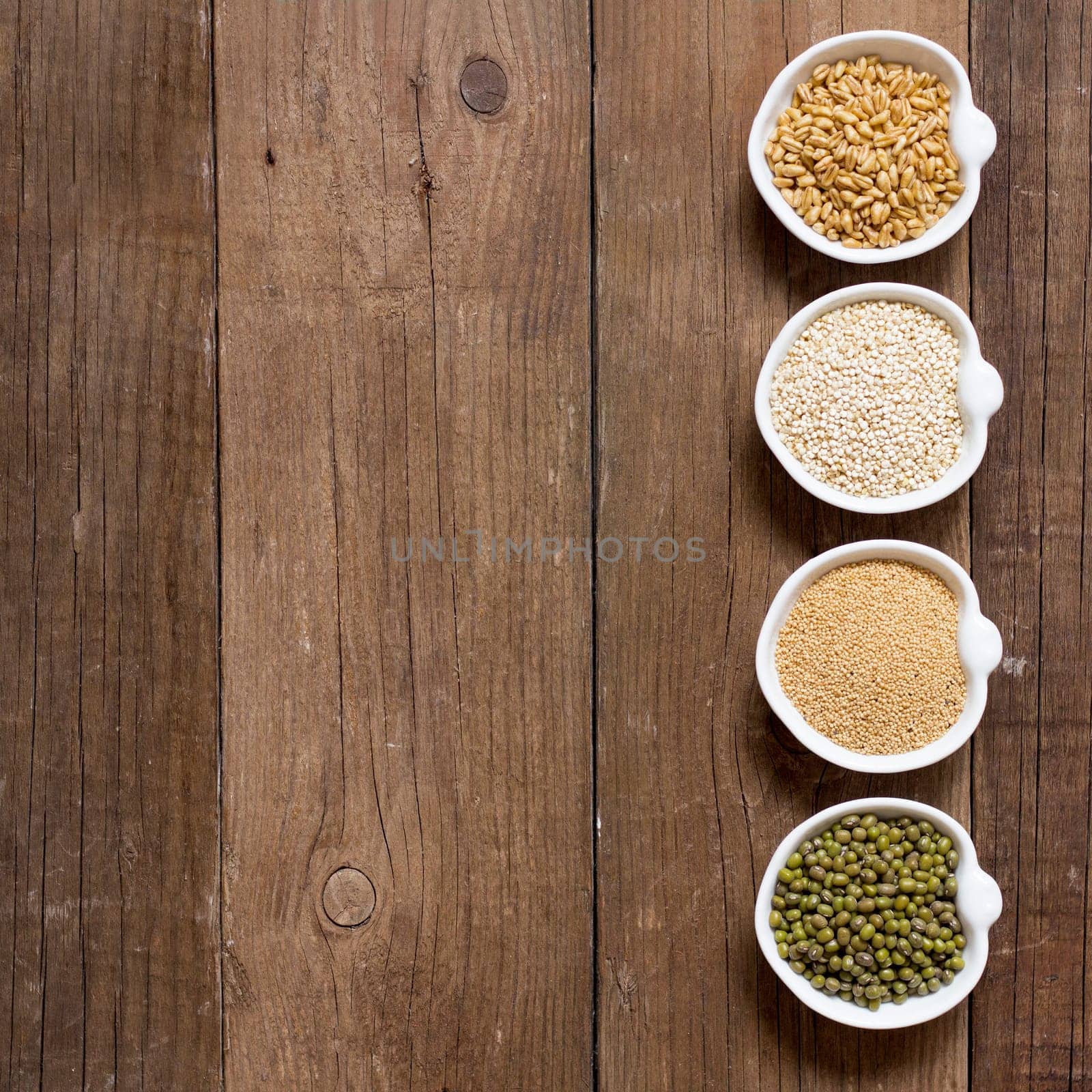 Raw Organic Amaranth and quinoa grains, wheat and mung beans in small bowls
