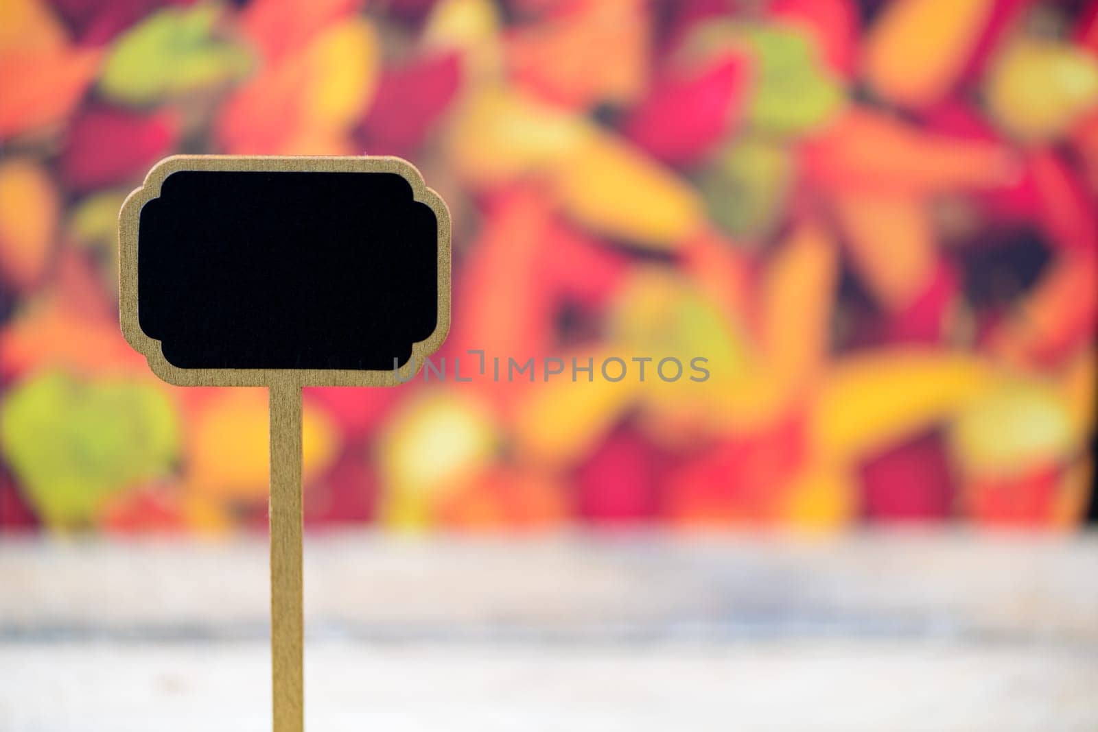 Wooden mini blackboard label over chilli peppers background and table, copy space available
