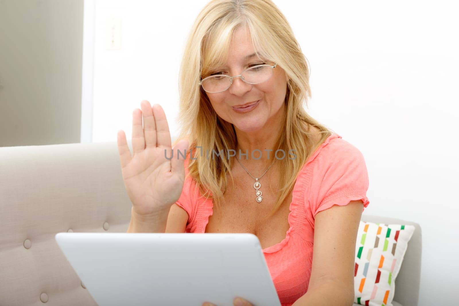 a beautiful mature woman using electronic tablet at home