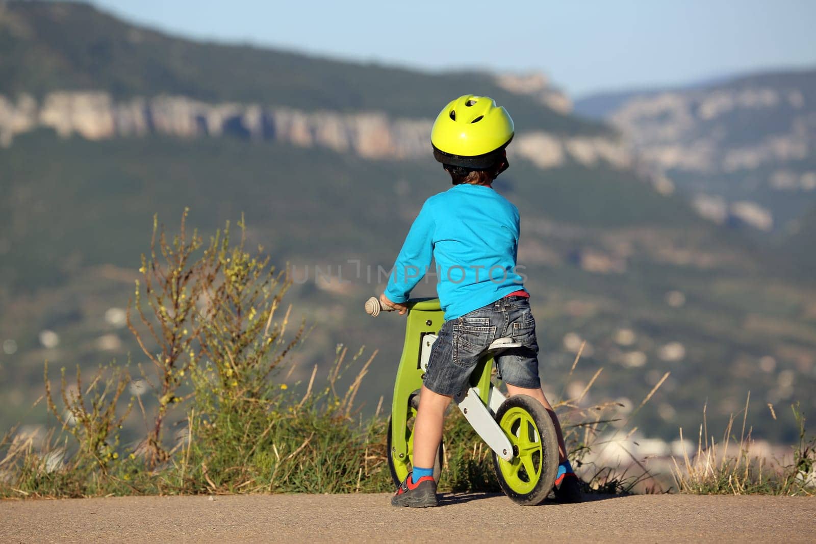 Little Boy Is On A Bike And It Looks The Mountain