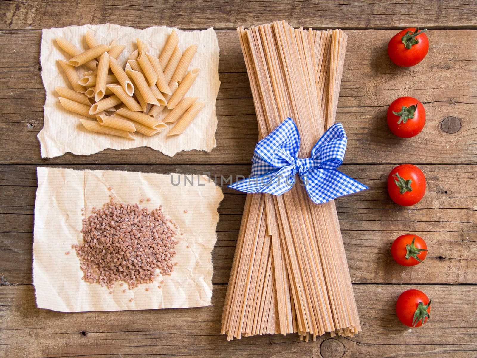Pasta and tomatoes on wooden background