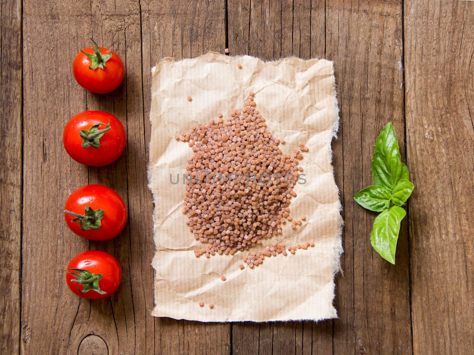 Pasta, tomatoes and basil on wooden background