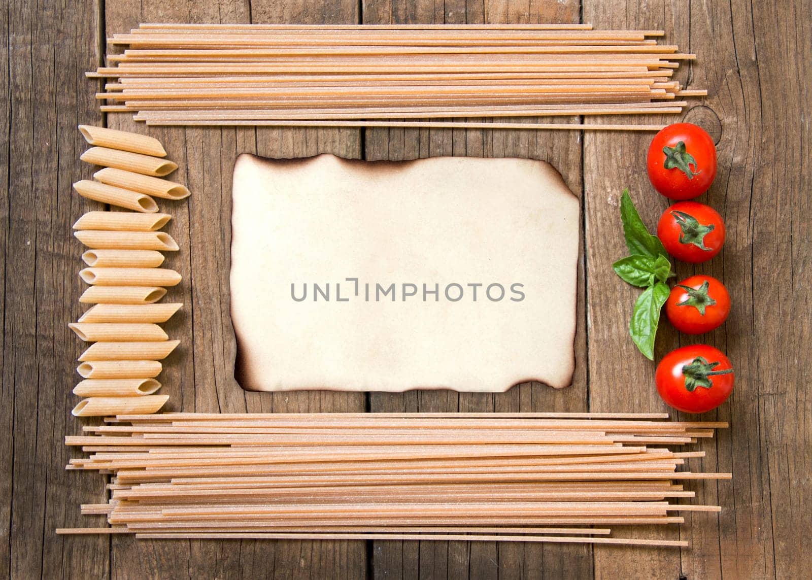 Pasta, tomatoes and basil on wooden background
