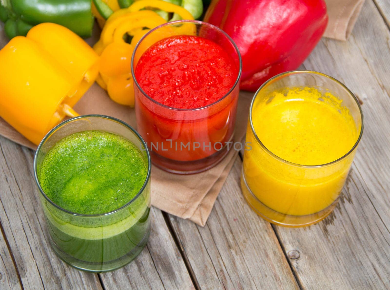 Fresh smoothies in the glass - green, red and yellow paprika