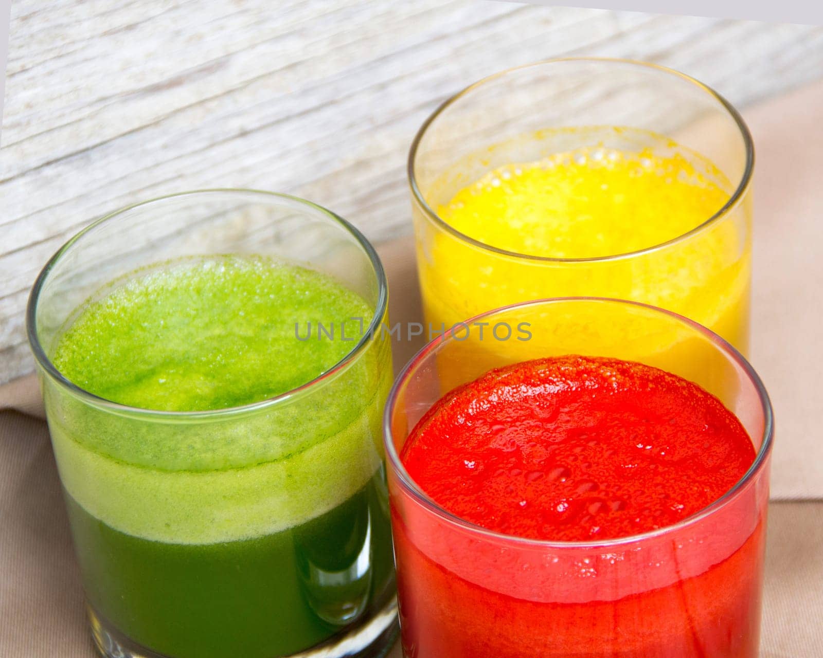 Fresh smoothies in the glass - green, red and yellow paprika