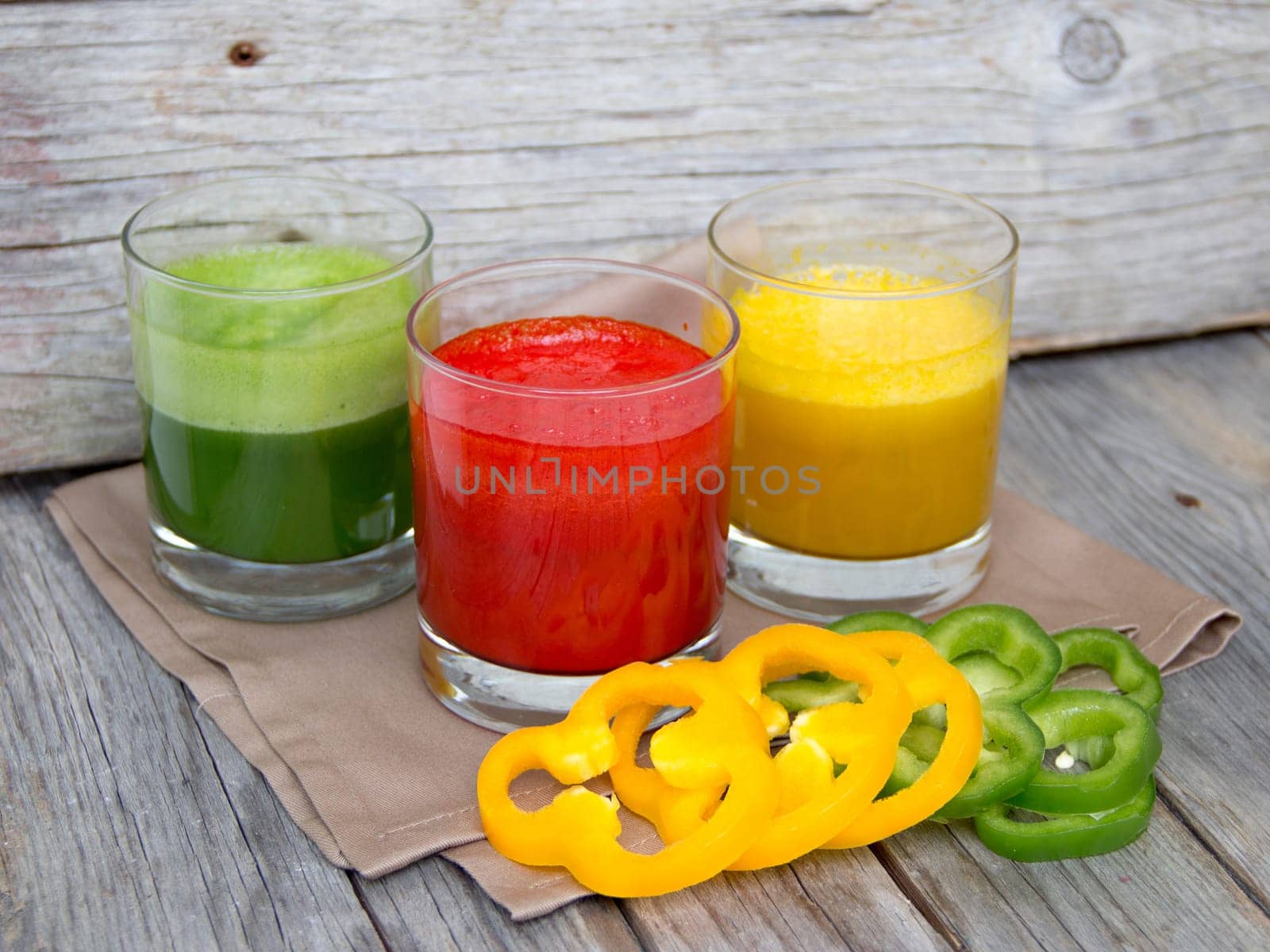 Fresh smoothies in the glass - green, red and yellow paprika
