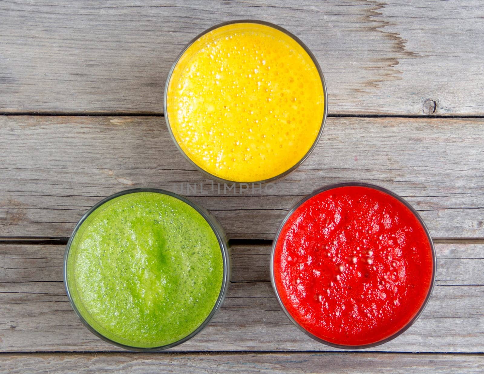 Fresh smoothies in the glass - green, red and yellow paprika