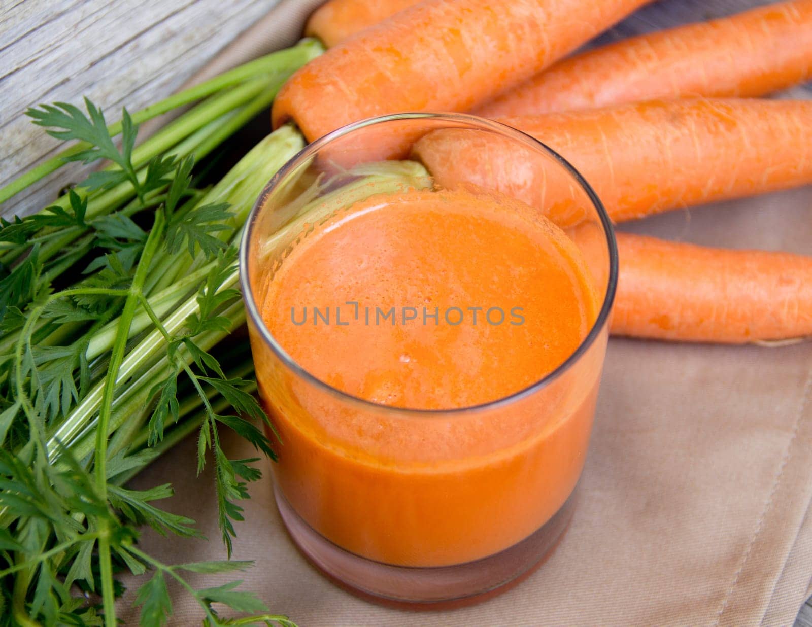 Fresh carrot juice on a wooden background
