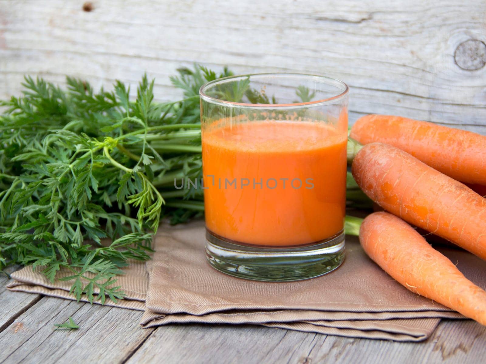 Fresh carrot juice on a wooden background