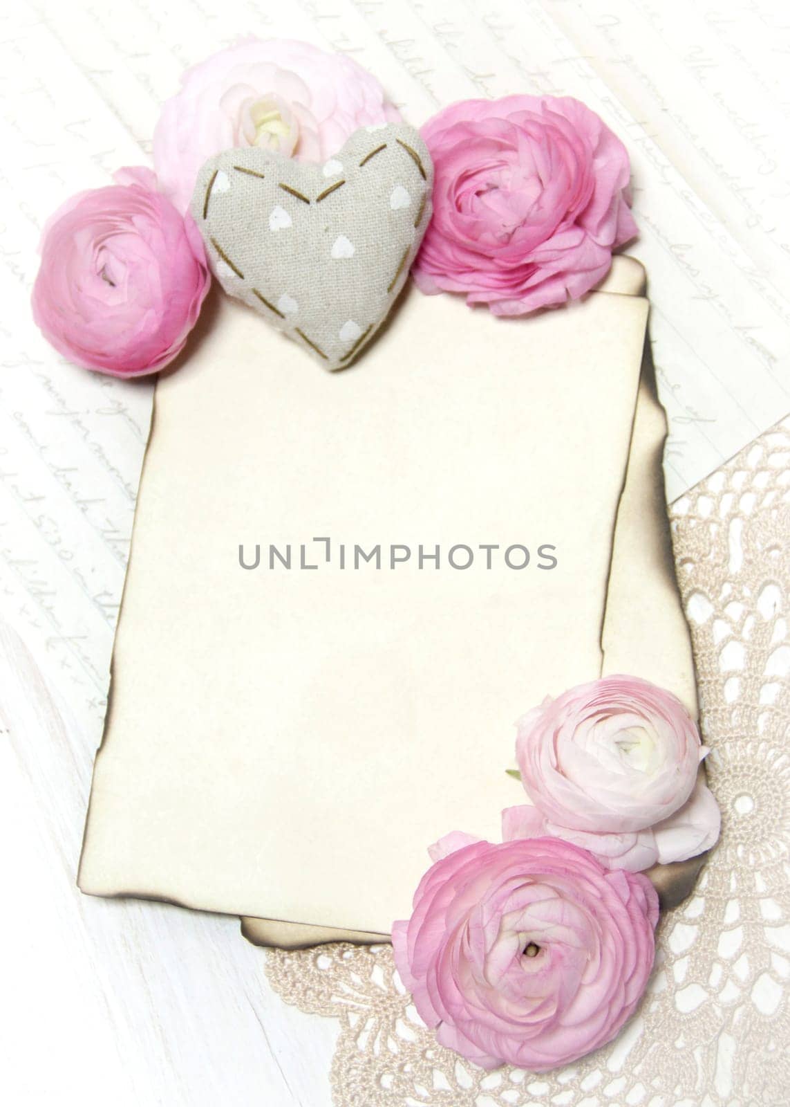 Ranunculus flowers, paper and heart background
