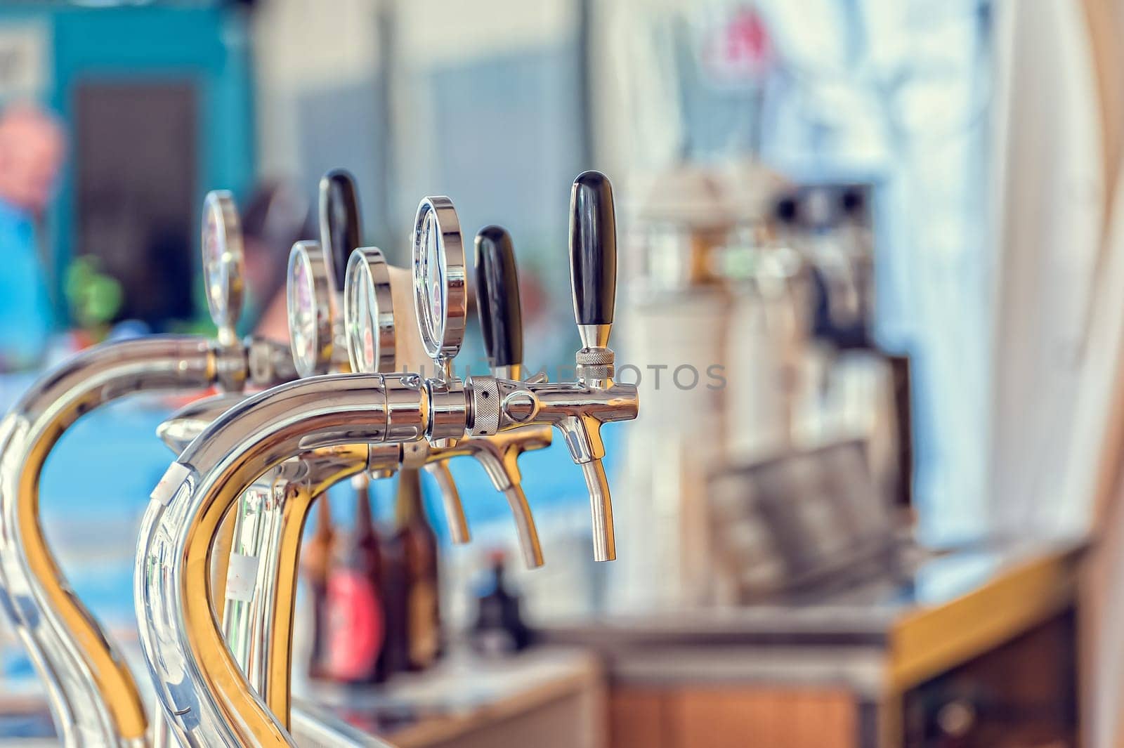 Draught beer taps and other beverages in a bar.