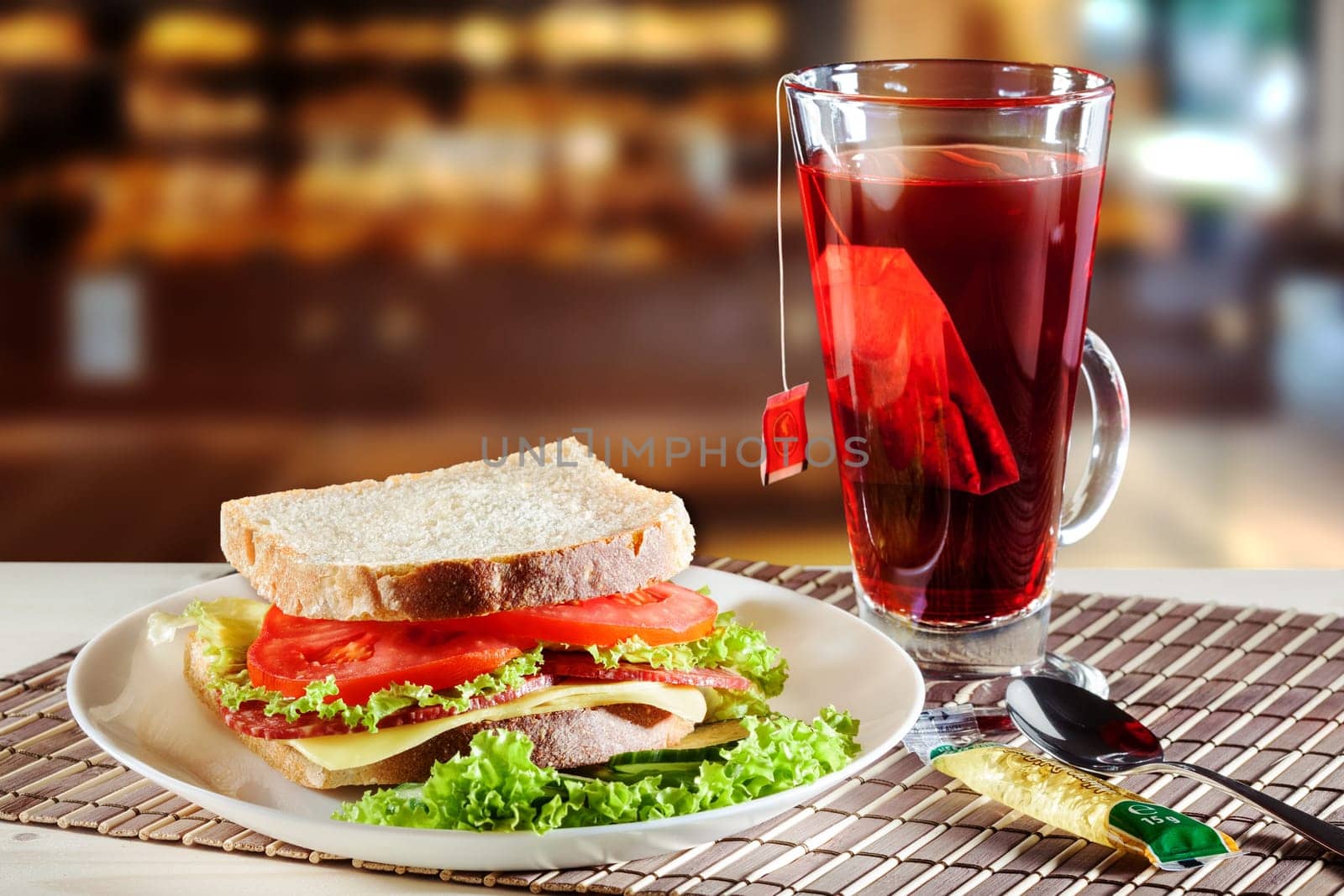 Sandwich with salami, cheese and salad and red fruit tea.