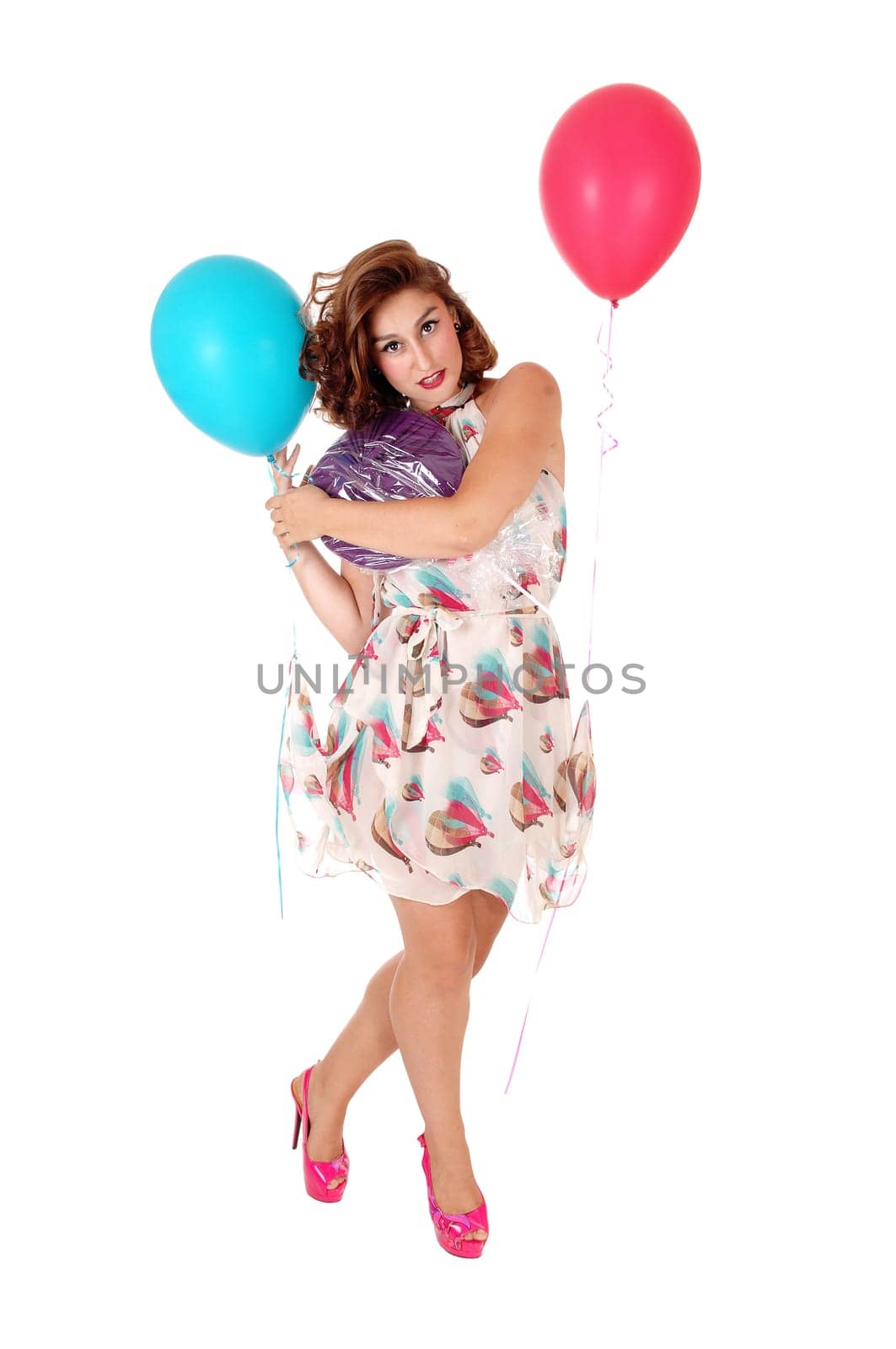 A gorgeous young woman standing in a dress with balloons attached.lifting her dress, isolated for white background..