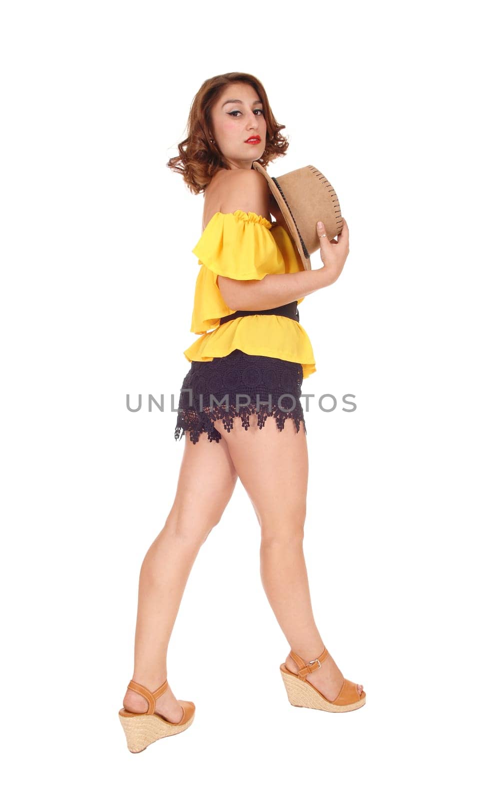 A lovely young woman posing in black shorts and yellow blouse with.a cowboy hat, isolated for white background..
