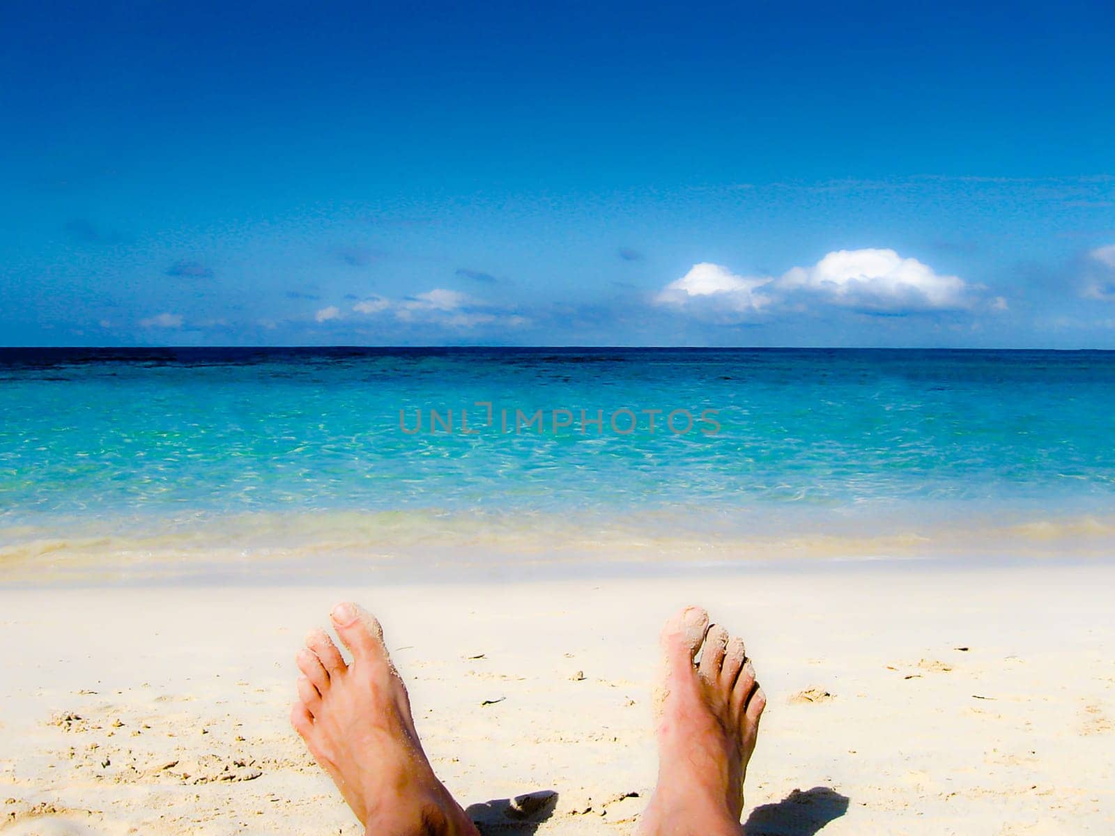 male feet at the sandy beach - legs of trousers