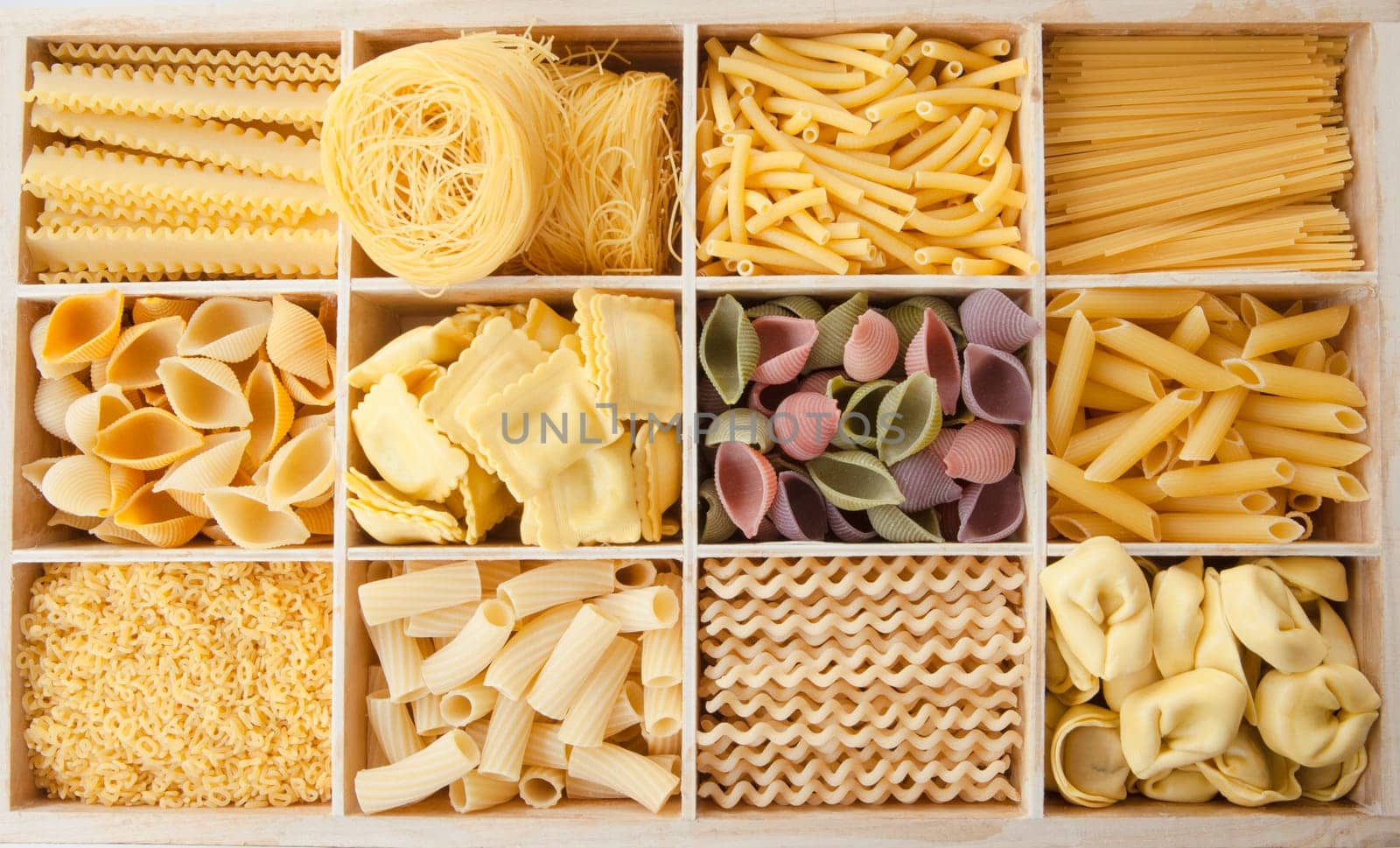 Different types of pasta sorted in boxes as a background