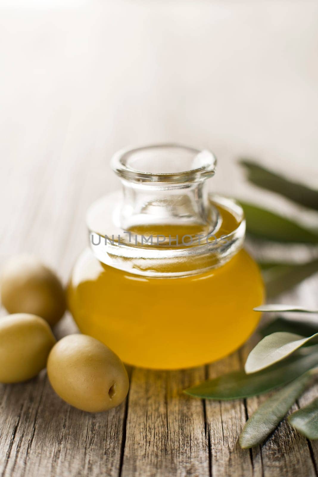 Olive oil in a bottle on a wooden table