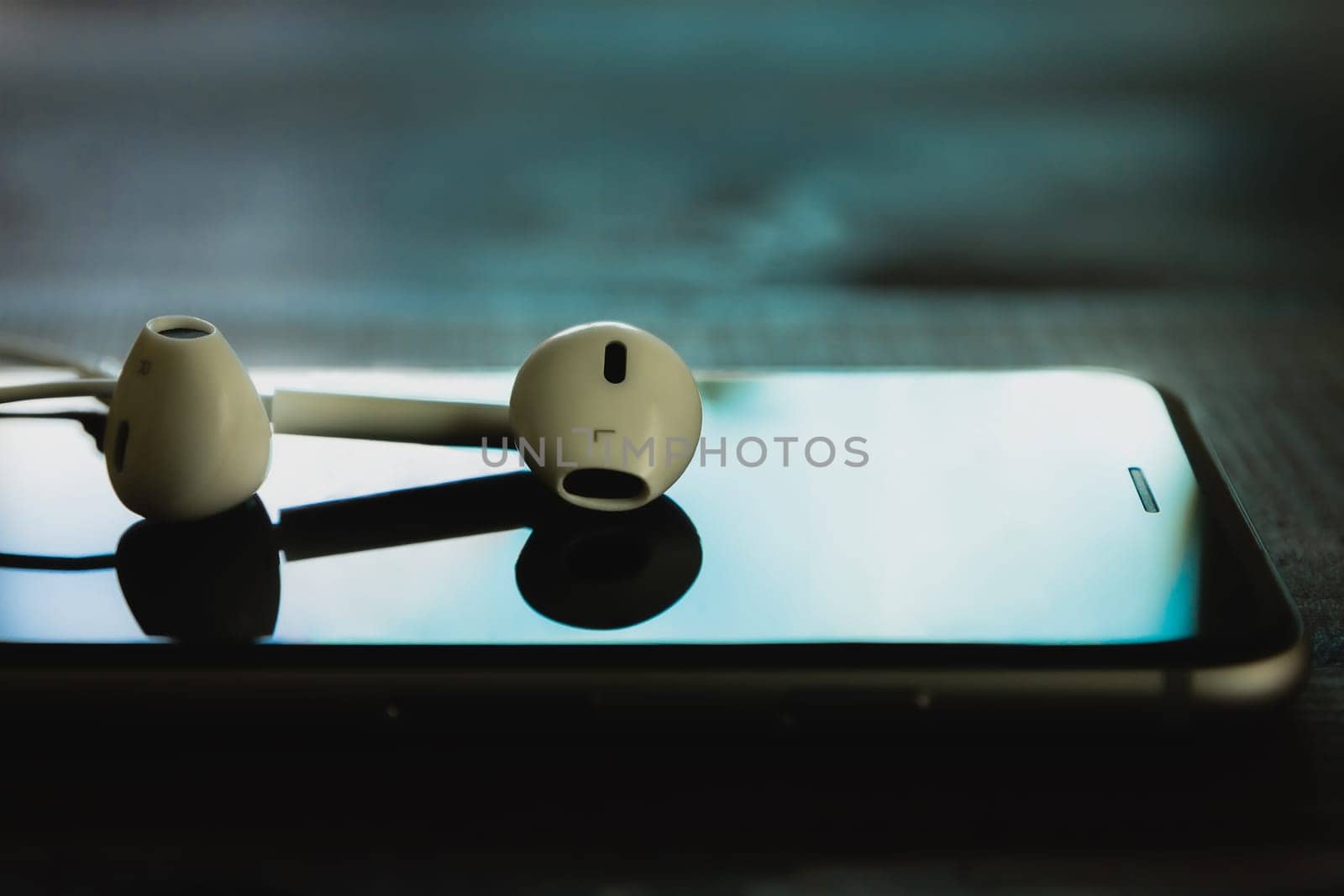 close up headphone stack on phone in black color tone, new headphone modern design device of phone technology